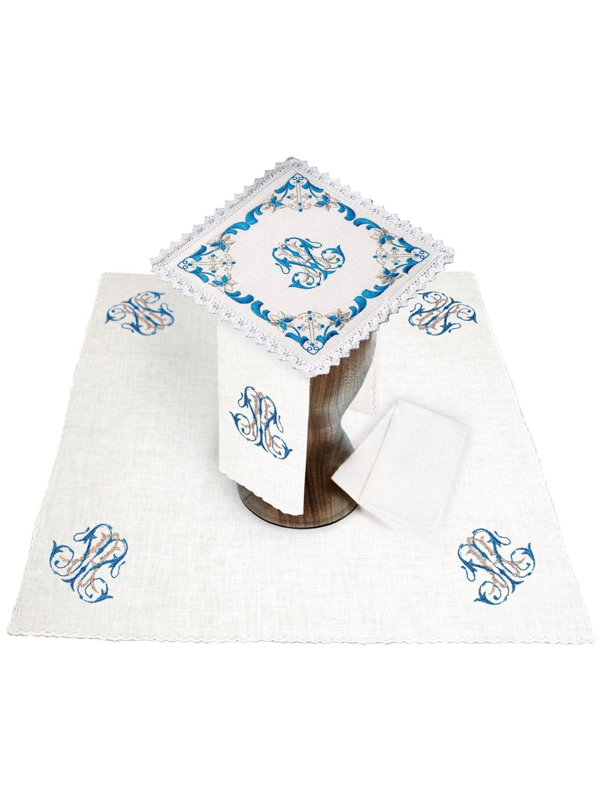 Conjunto de alfaias litúrgicas em linho com bordado mariano azul, vista geral com peças brancas e detalhes azuis