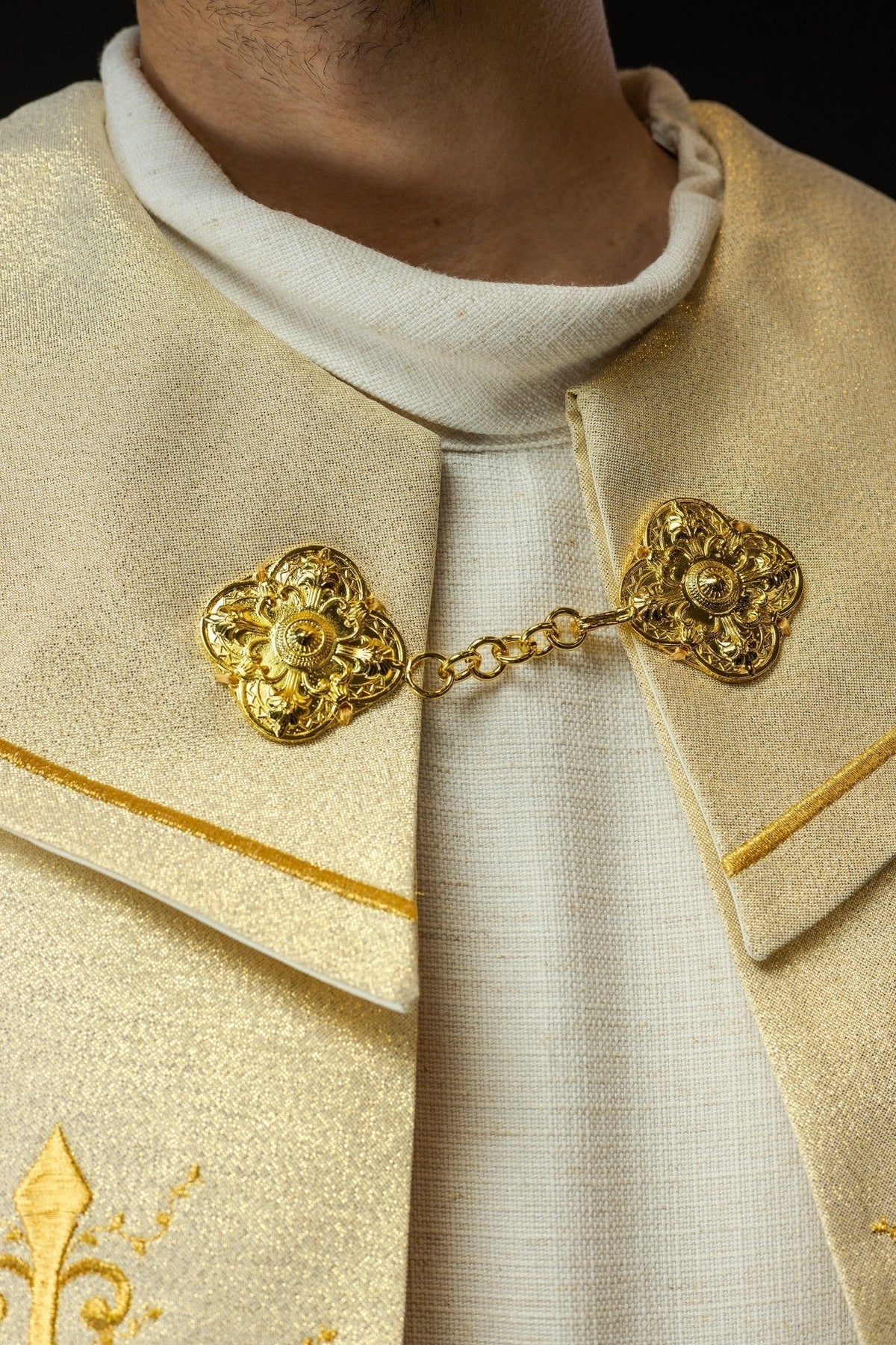 Capa de asperges dourada, detalhe do fecho com corrente e ornamentos dourados