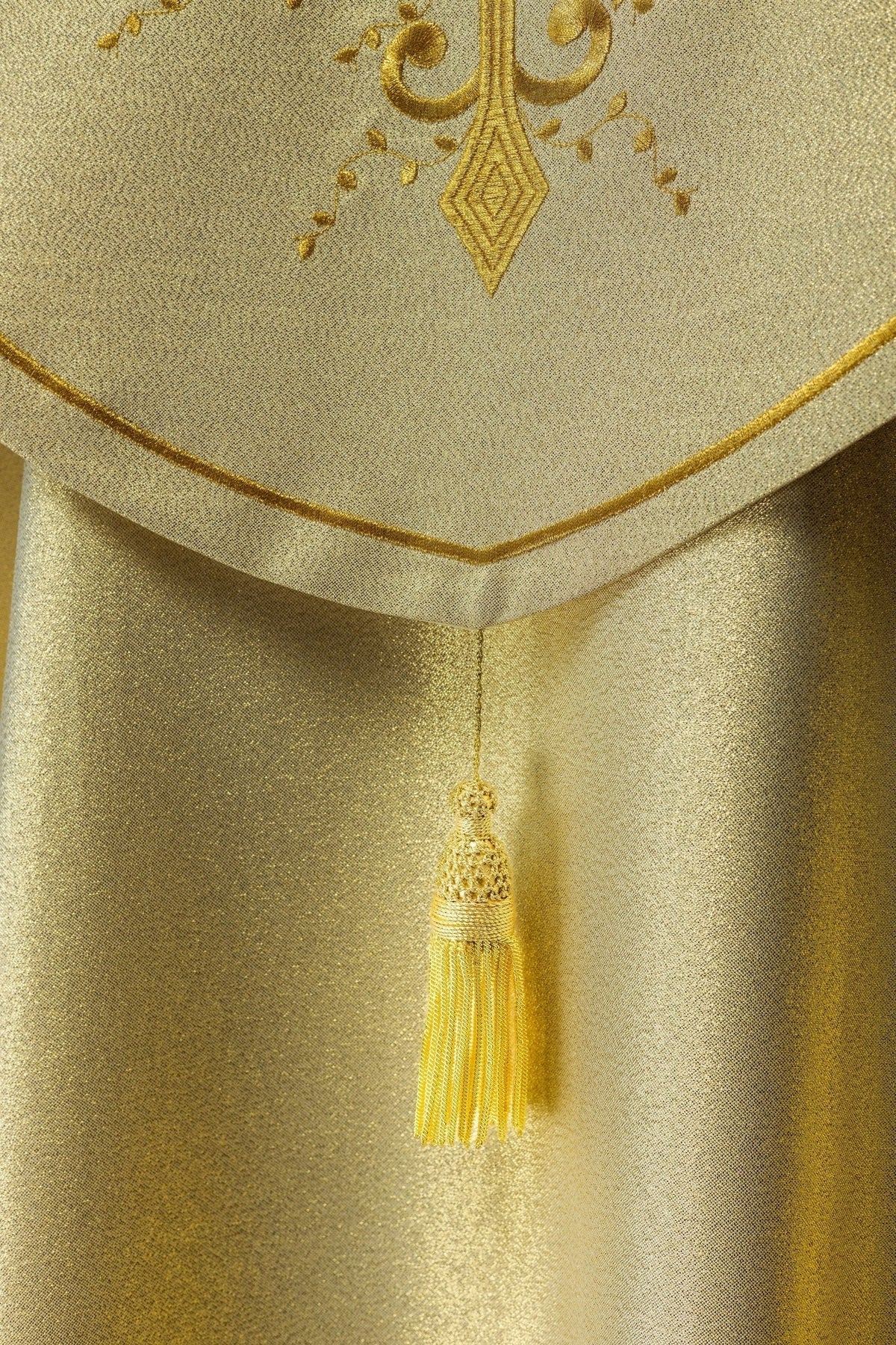 Capa de asperges dourada, detalhe da borda e da borla central