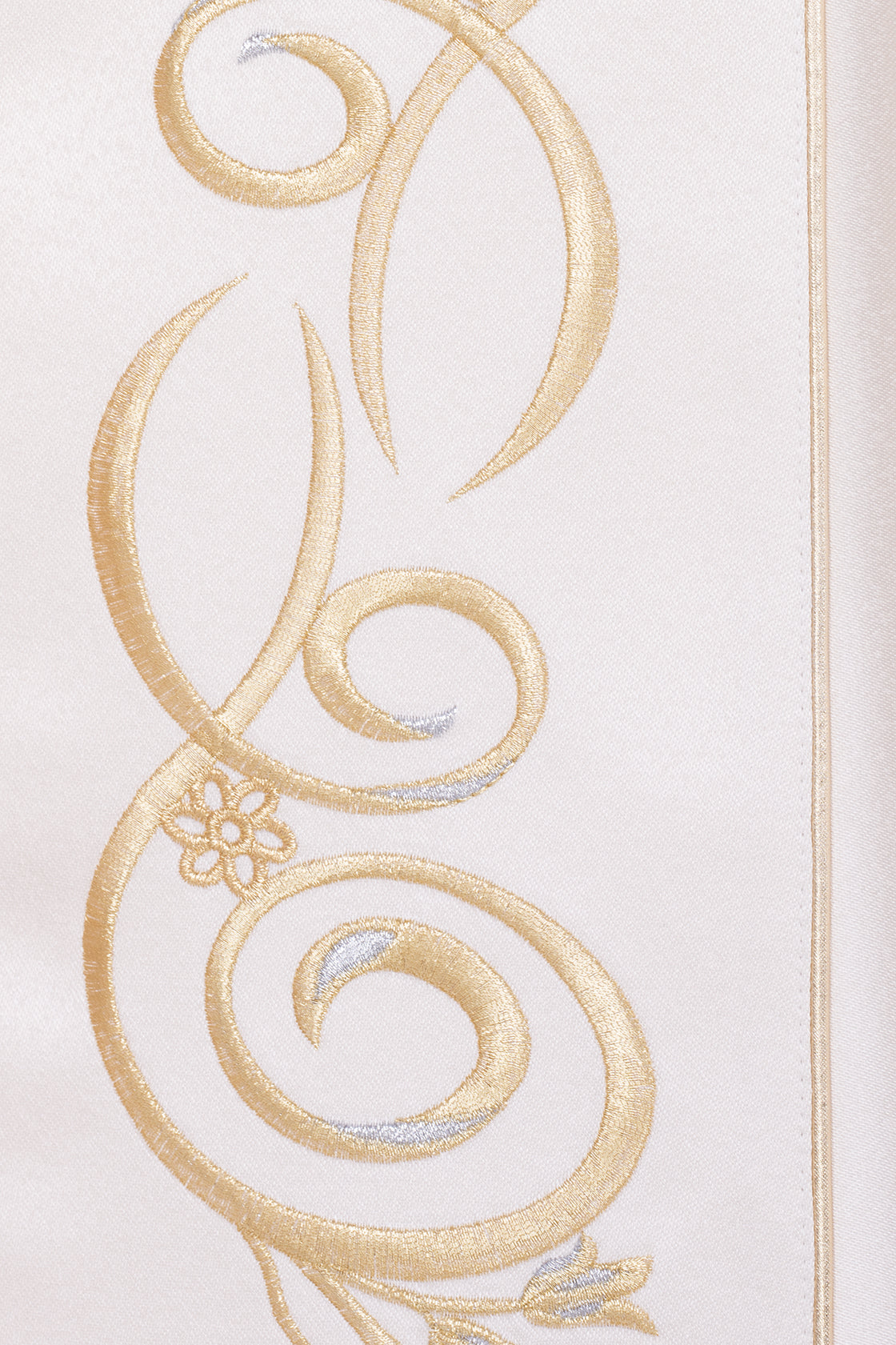 Capa de asperges ecru em close, detalhe do bordado dourado com arabescos