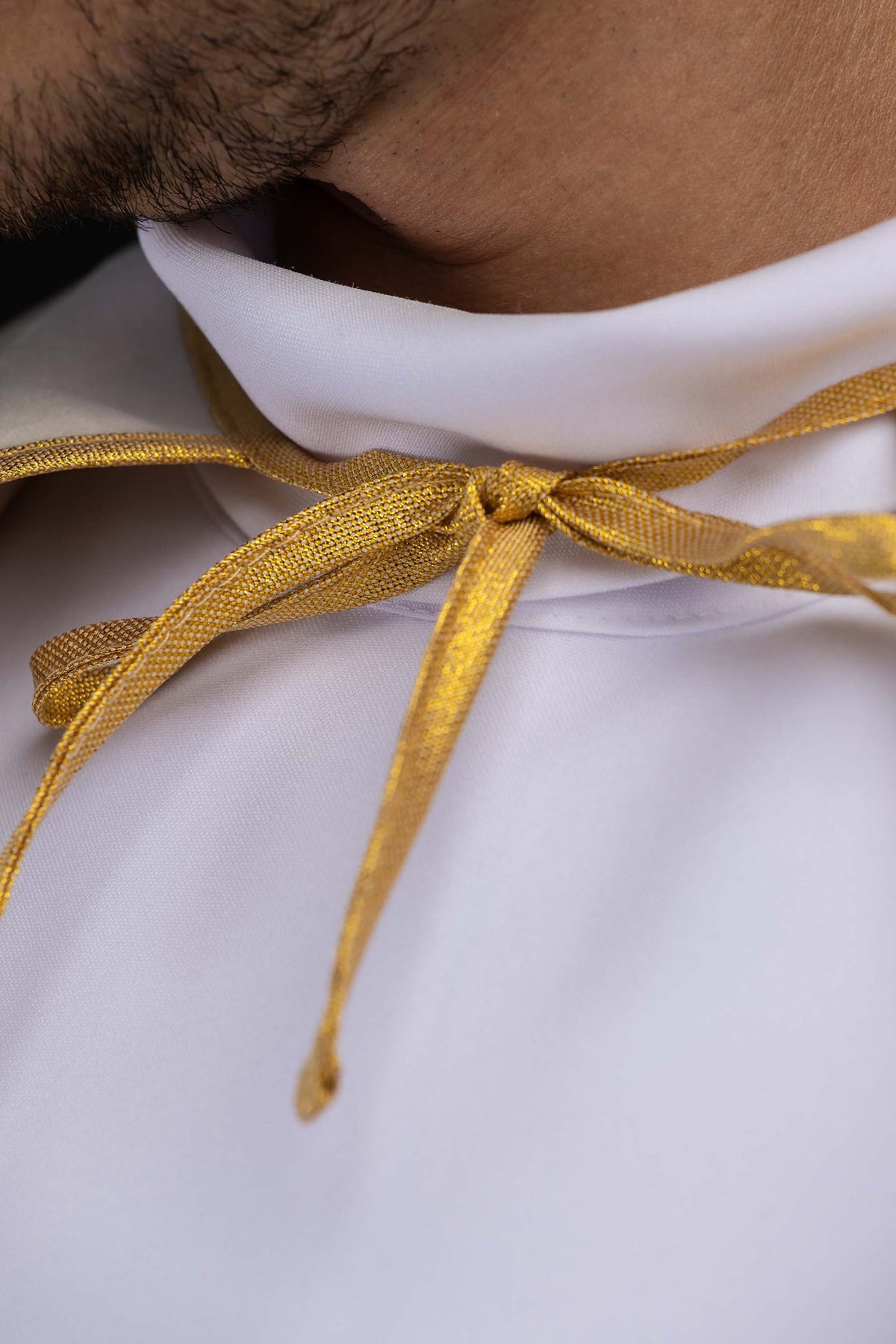 Capa de coroinha marfim ecru em close-up do viés dourado
