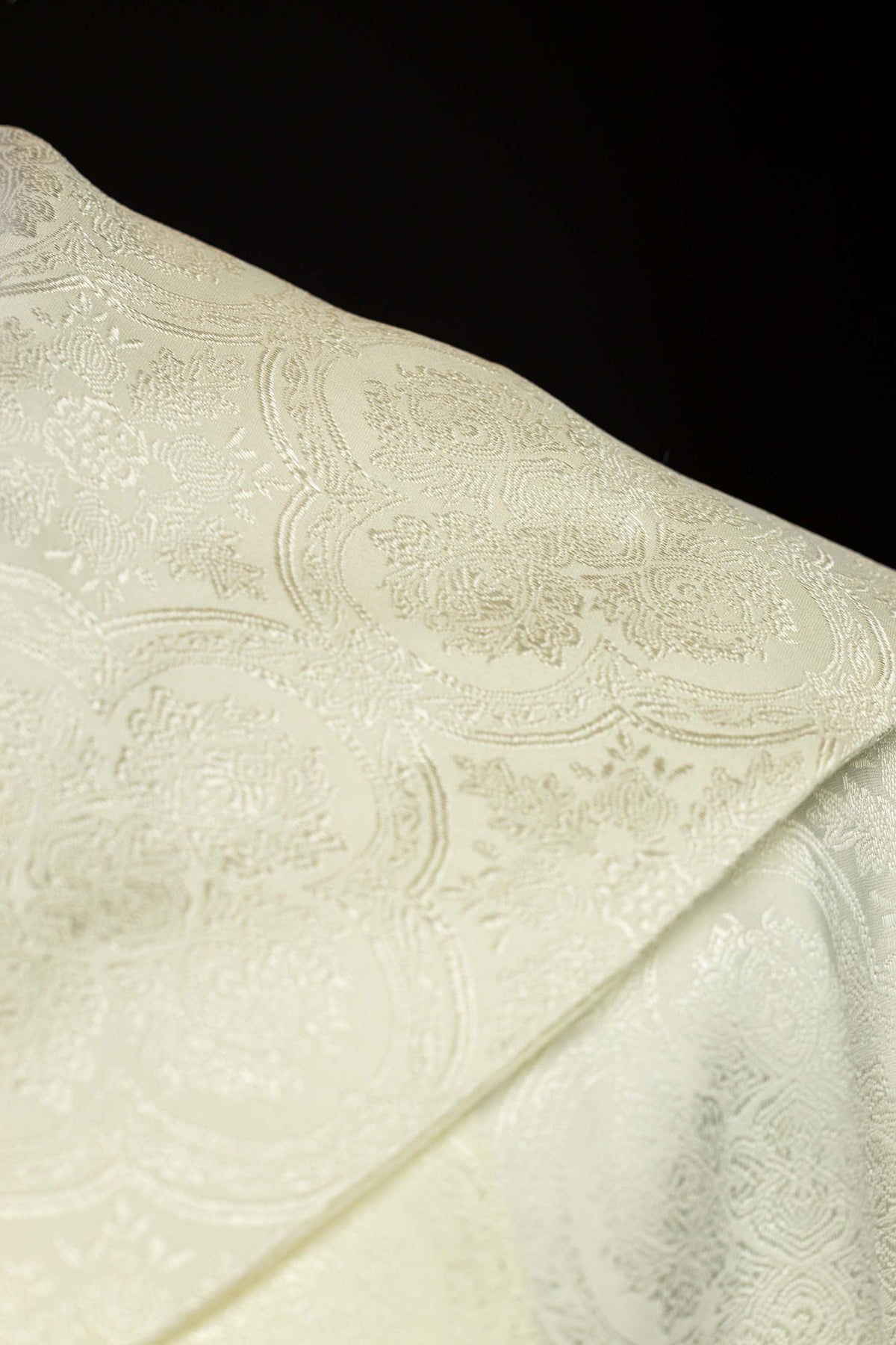 Capa de asperges creme em close do tecido jacquard com motivos adamascados
