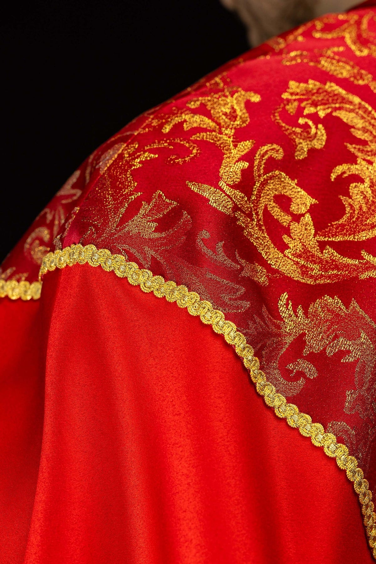 Capa de asperges vermelha vista pelas costas, com tecido jacquard dourado e borla central