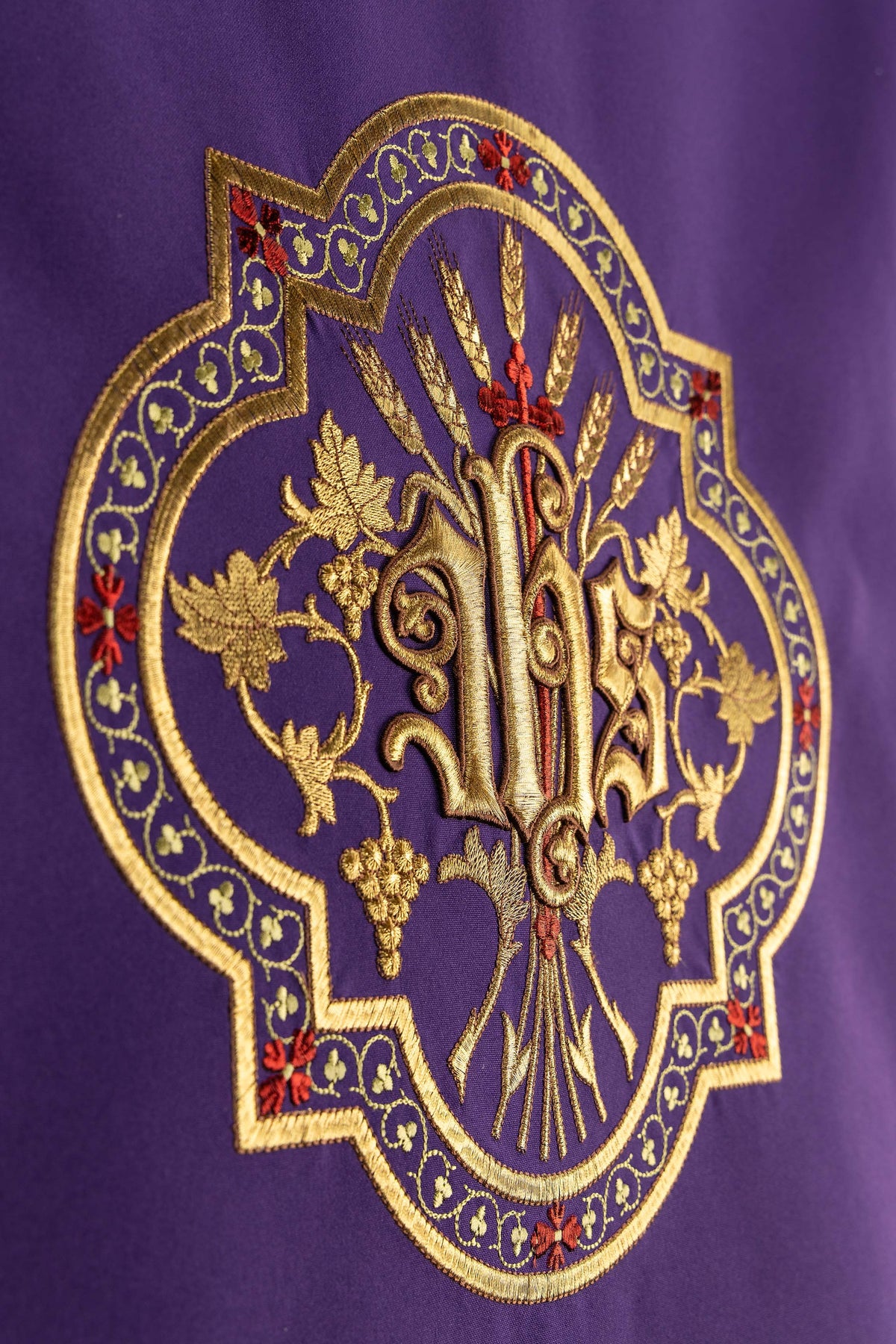 Pano de ambão roxo com emblema JHS dourado e detalhes vermelhos
