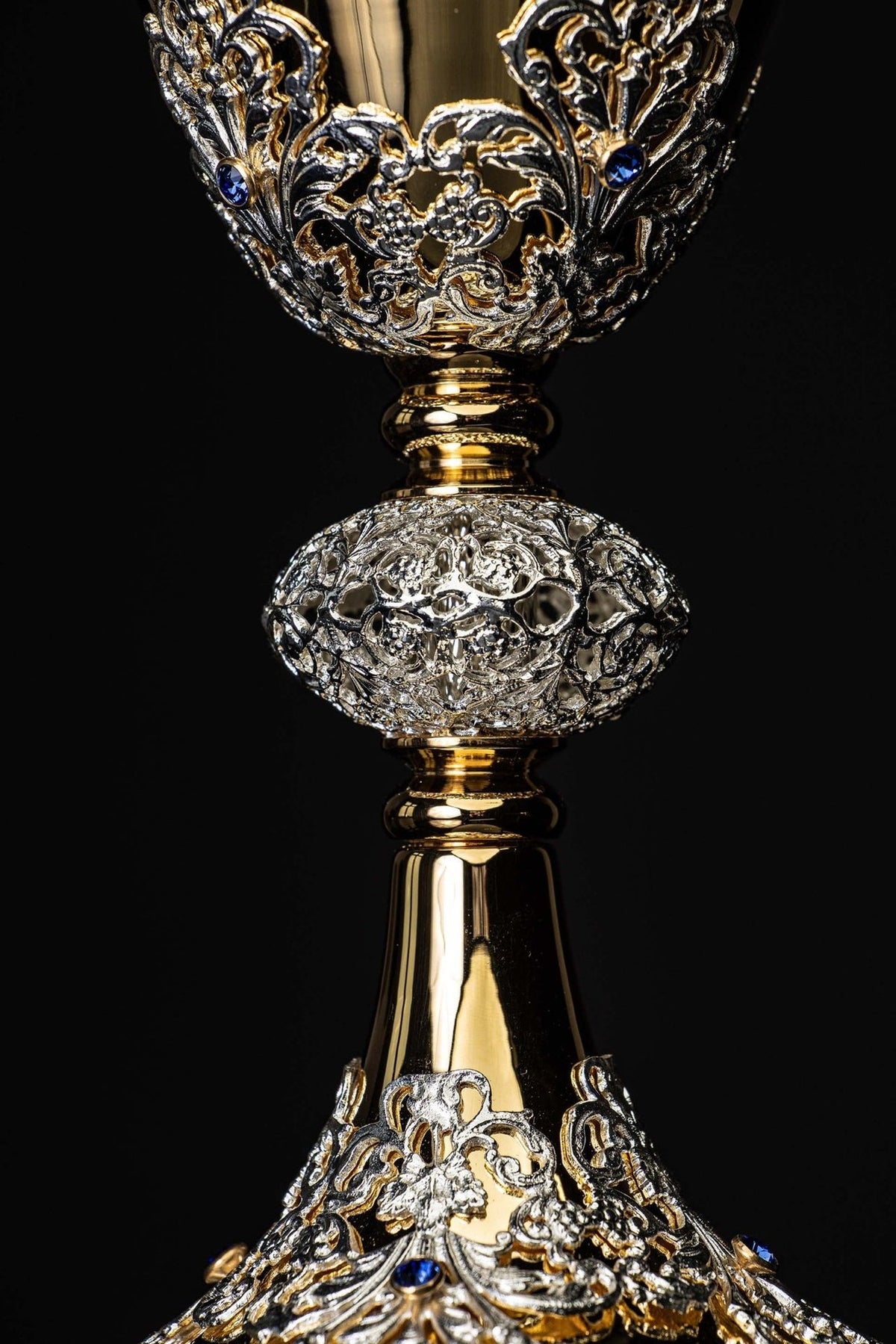 Cálice litúrgico com ornamentos prateados e dourados no bojo e na base