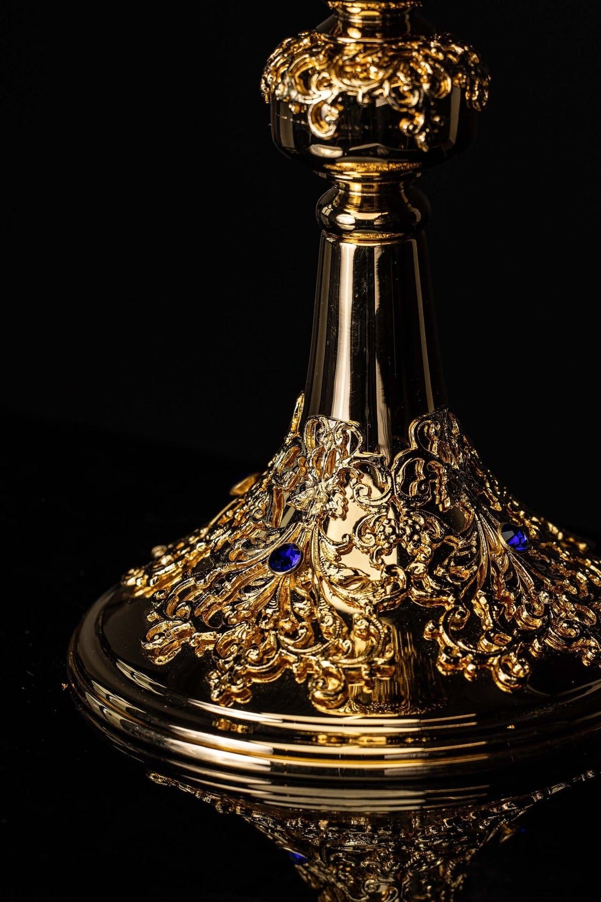 Âmbula dourada em close-up frontal da copa e do nó com ornamentos em relevo