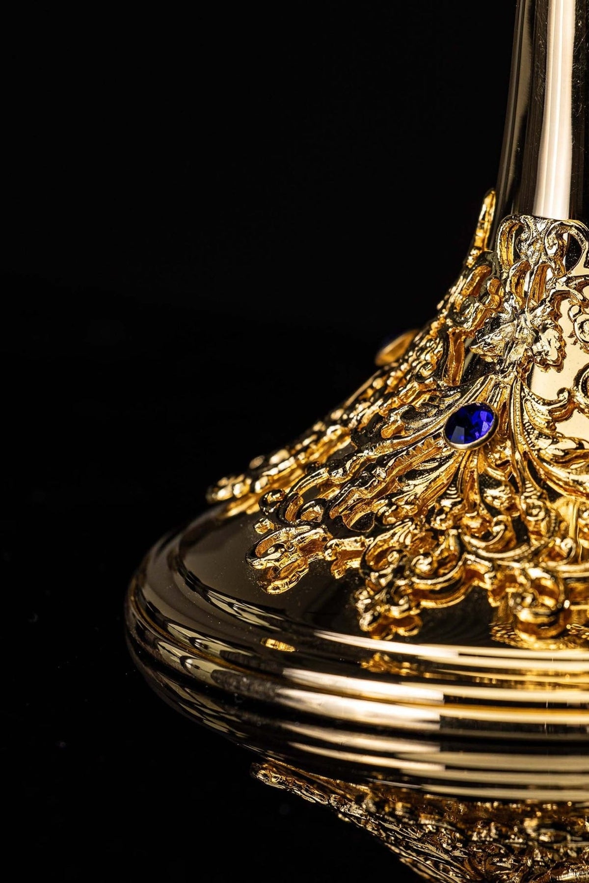 Âmbula dourada em close-up da base ornamentada com safiras azuis