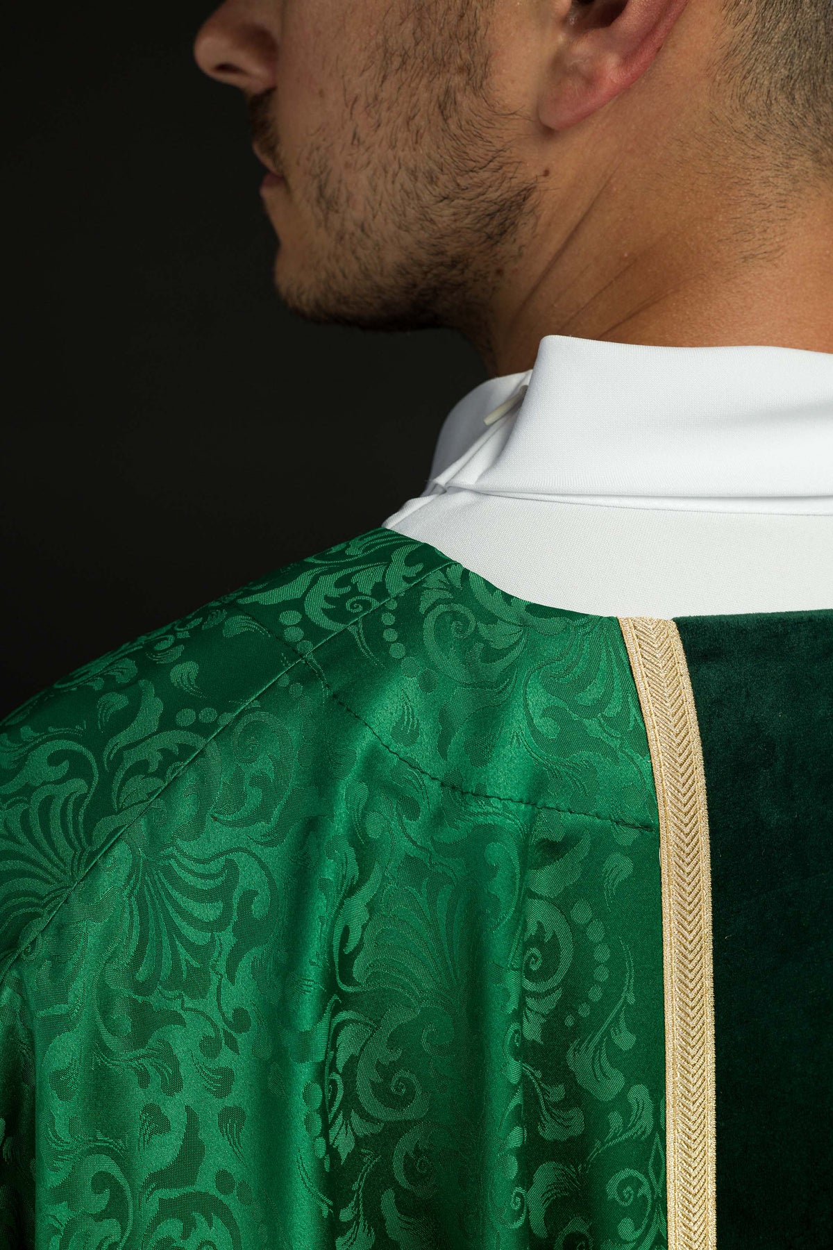Casula verde em close-up do colarinho, faixa dourada e tecido jacquard