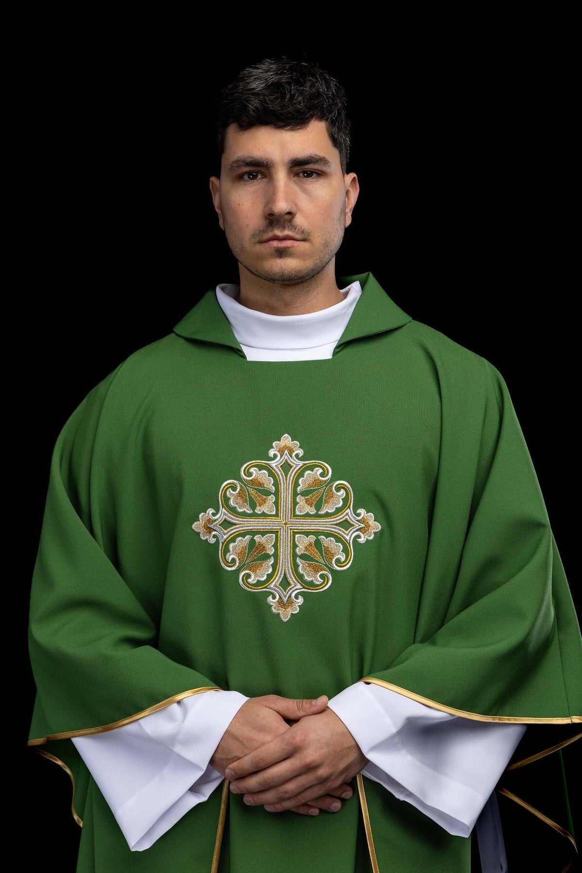 Casula verde bordada com cruz ornamentada e gola larga, vista frontal e usada