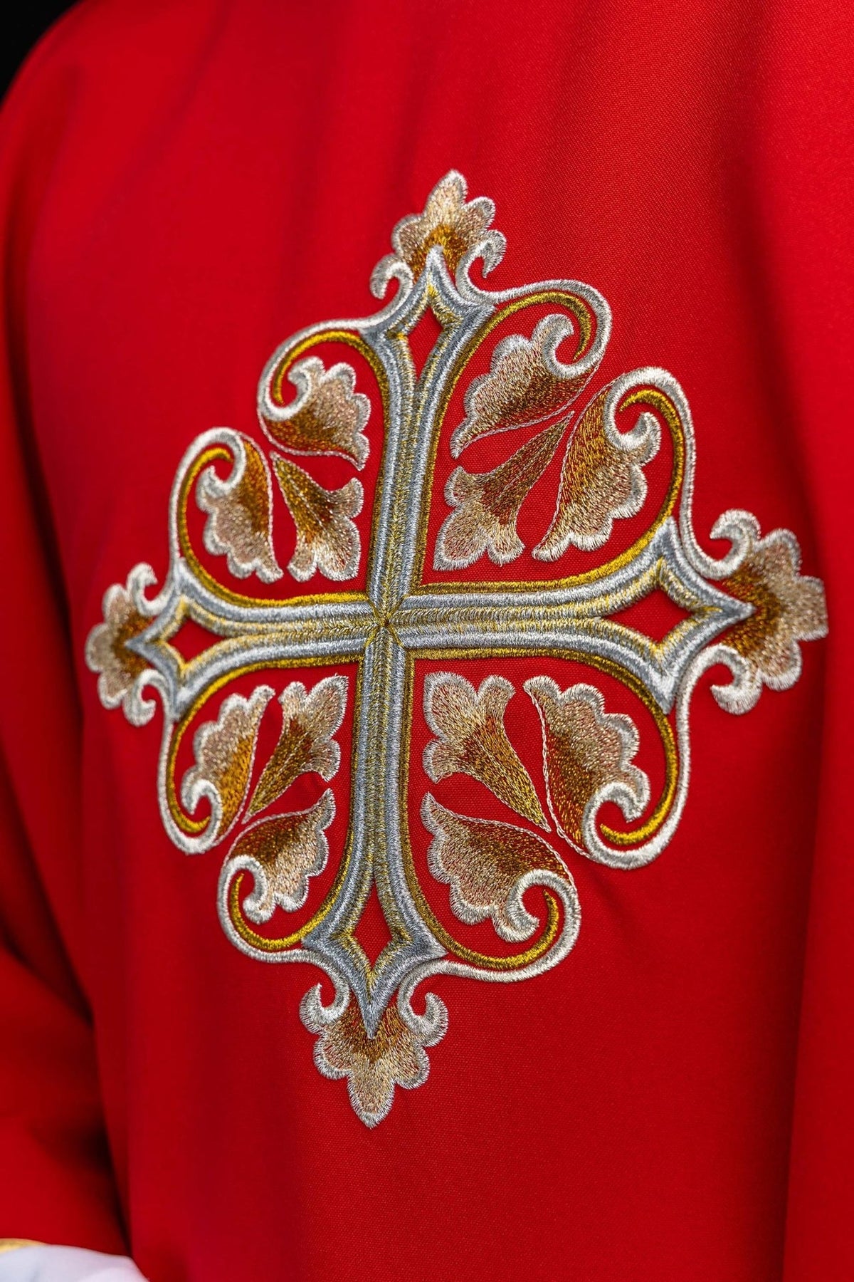Casula com close-up da cruz ornamentada em bordado dourado e prateado