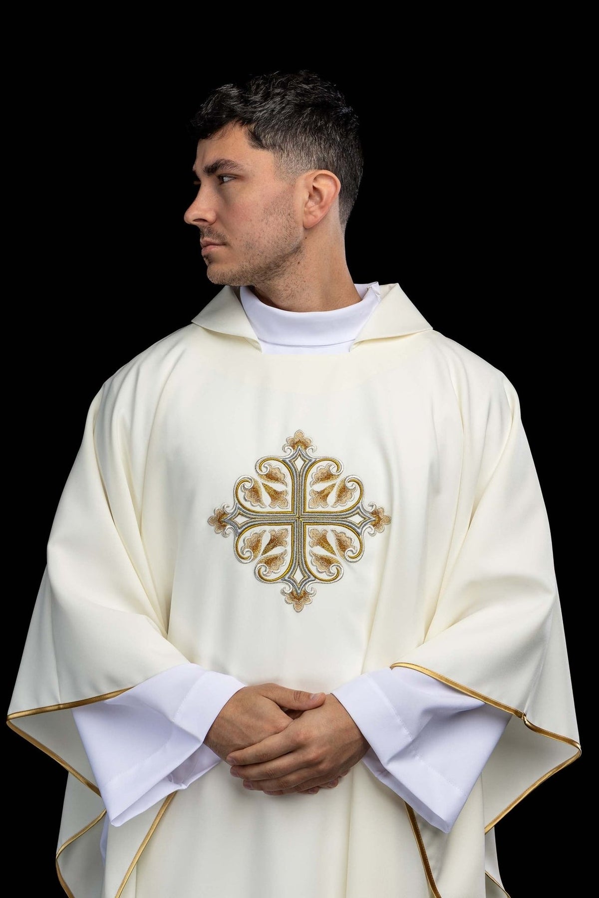 Casula litúrgica bordada na cor marfim ecru, com cruz decorada, gola larga e viés dourado, vista frontal