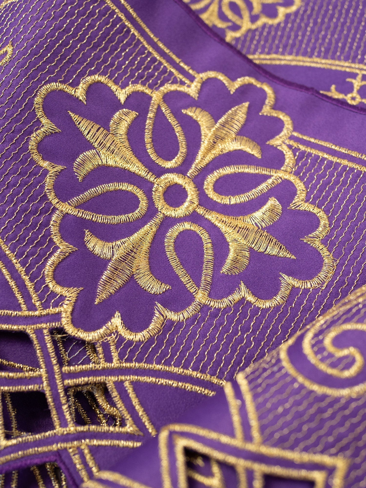 Tecido para toalha de altar roxo, close-up do bordado dourado em formato de roseta