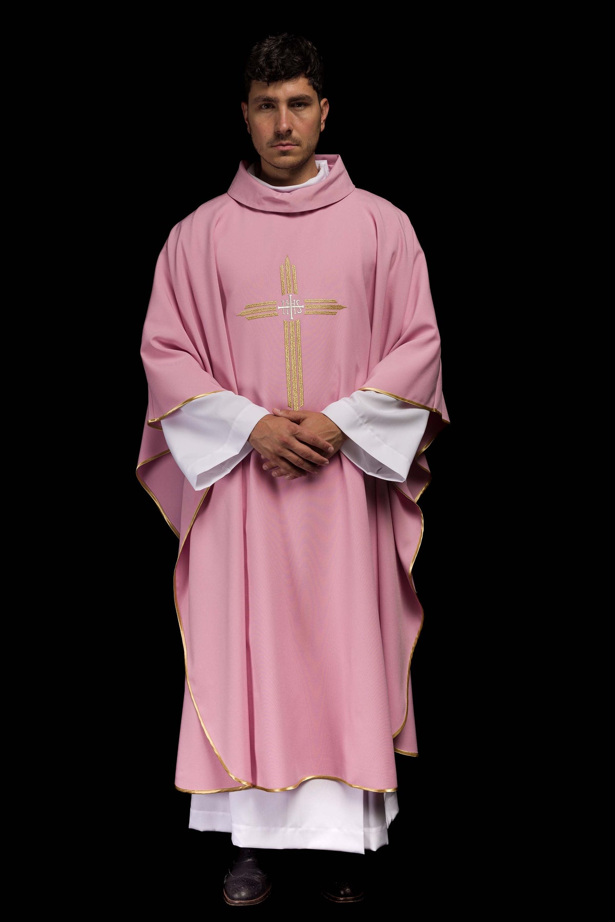 Casula rosa vista de frente em corpo inteiro, com bordado IHS dourado