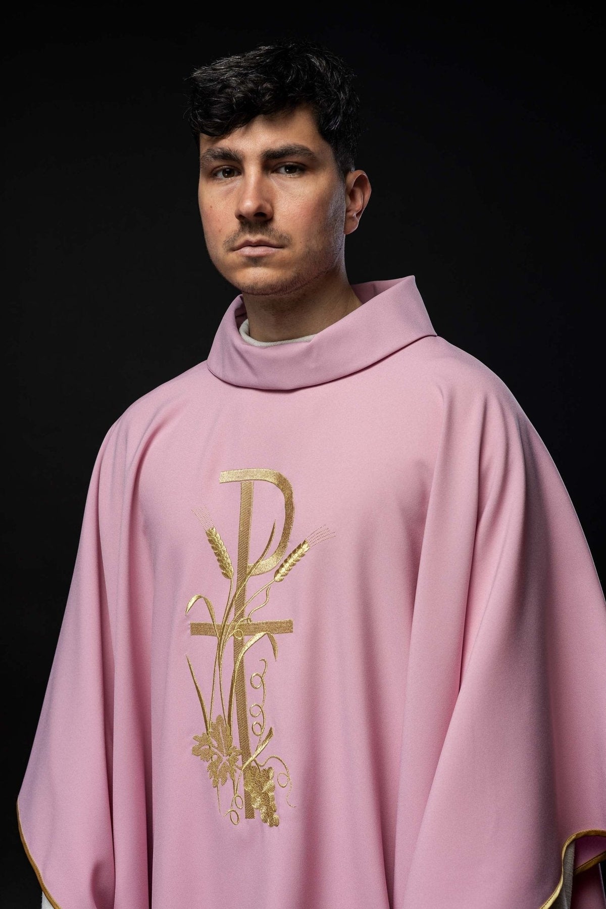 Casula rosa com bordado dourado PAX vista frontal aproximada, com cruz, trigo, uvas e acabamento dourado