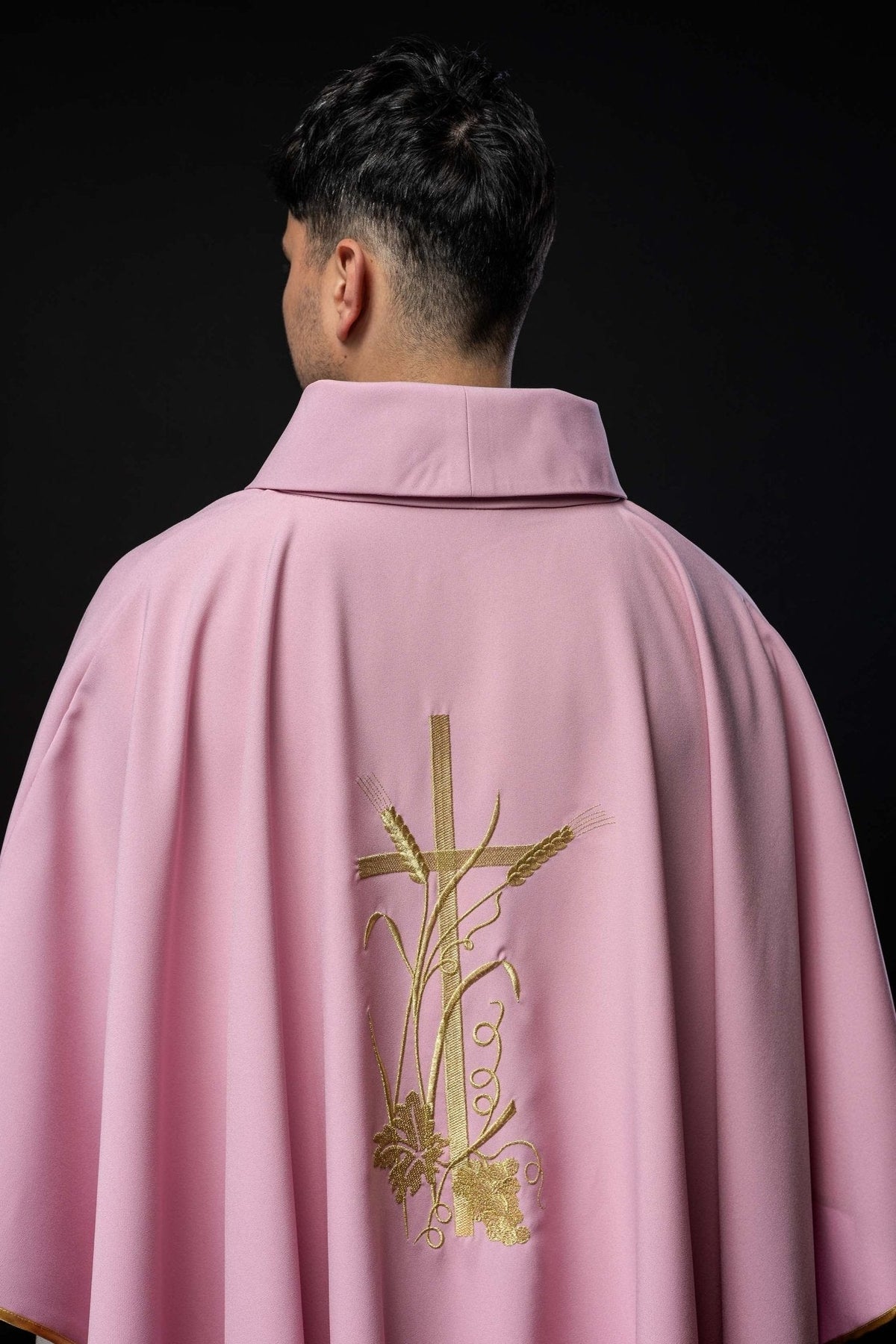 Casula rosa com bordado dourado PAX vista traseira aproximada, com bordado central dourado