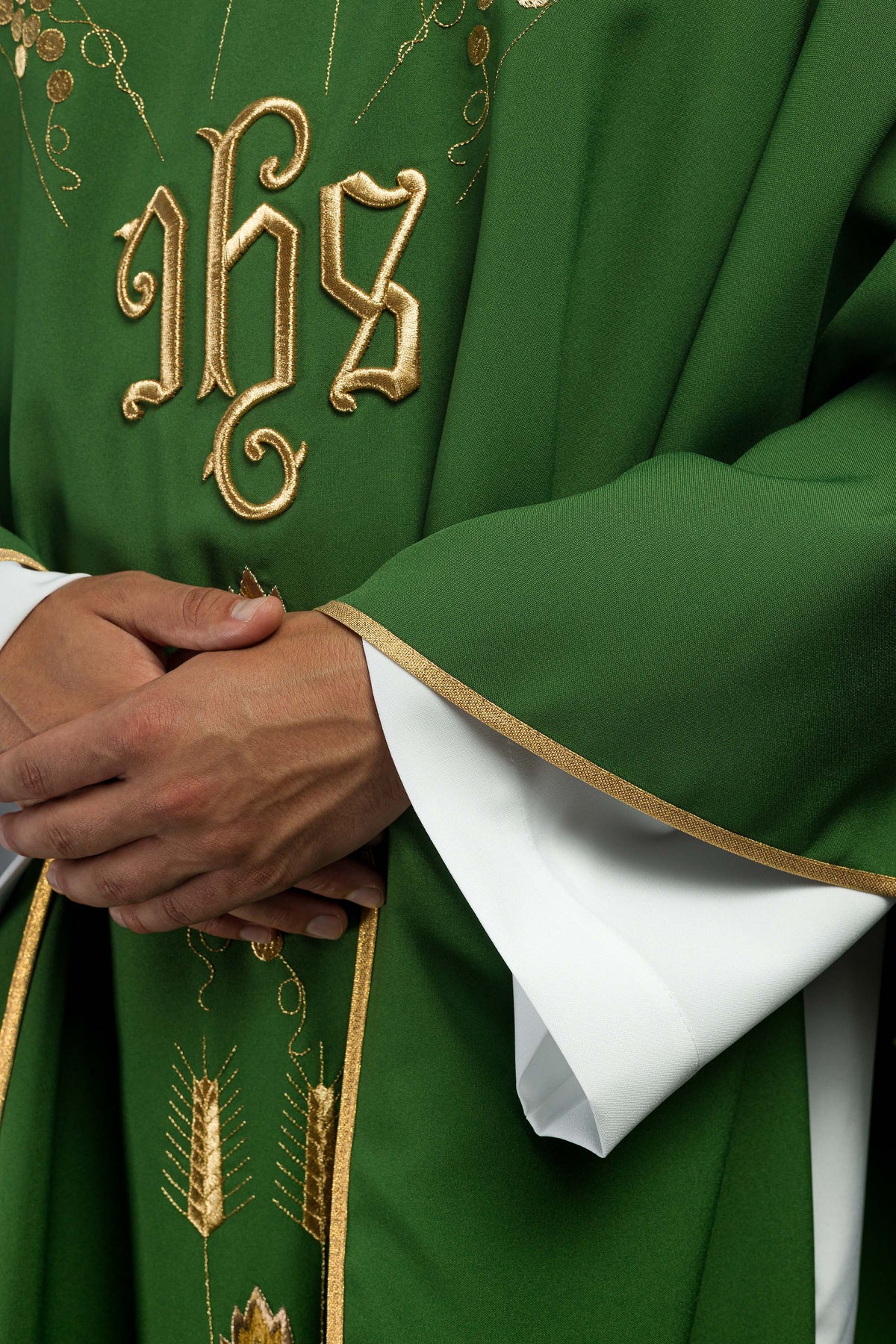Casula verde, detalhe da manga ampla com acabamento dourado e bordado frontal