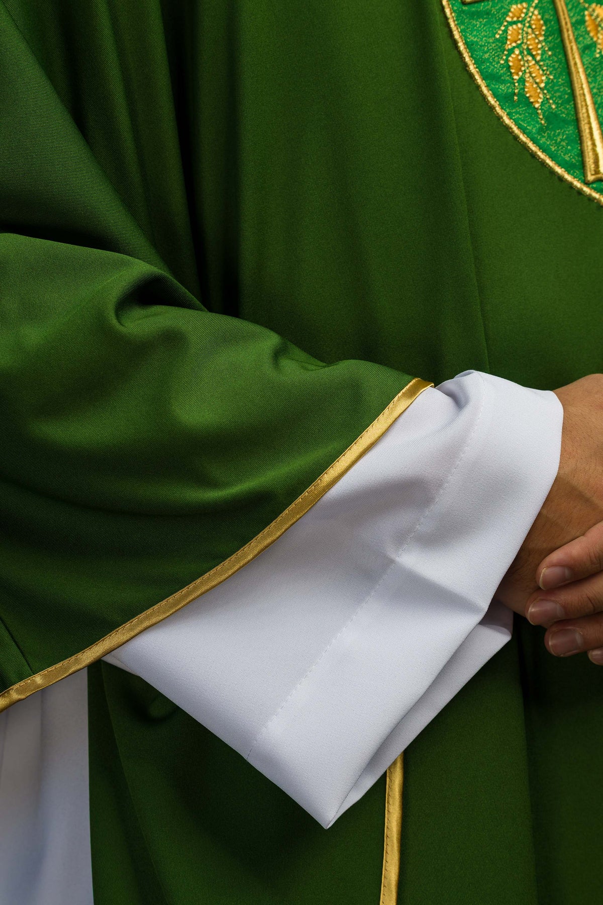 Casula verde Sacrolite, detalhe da manga com punho branco e viés dourado