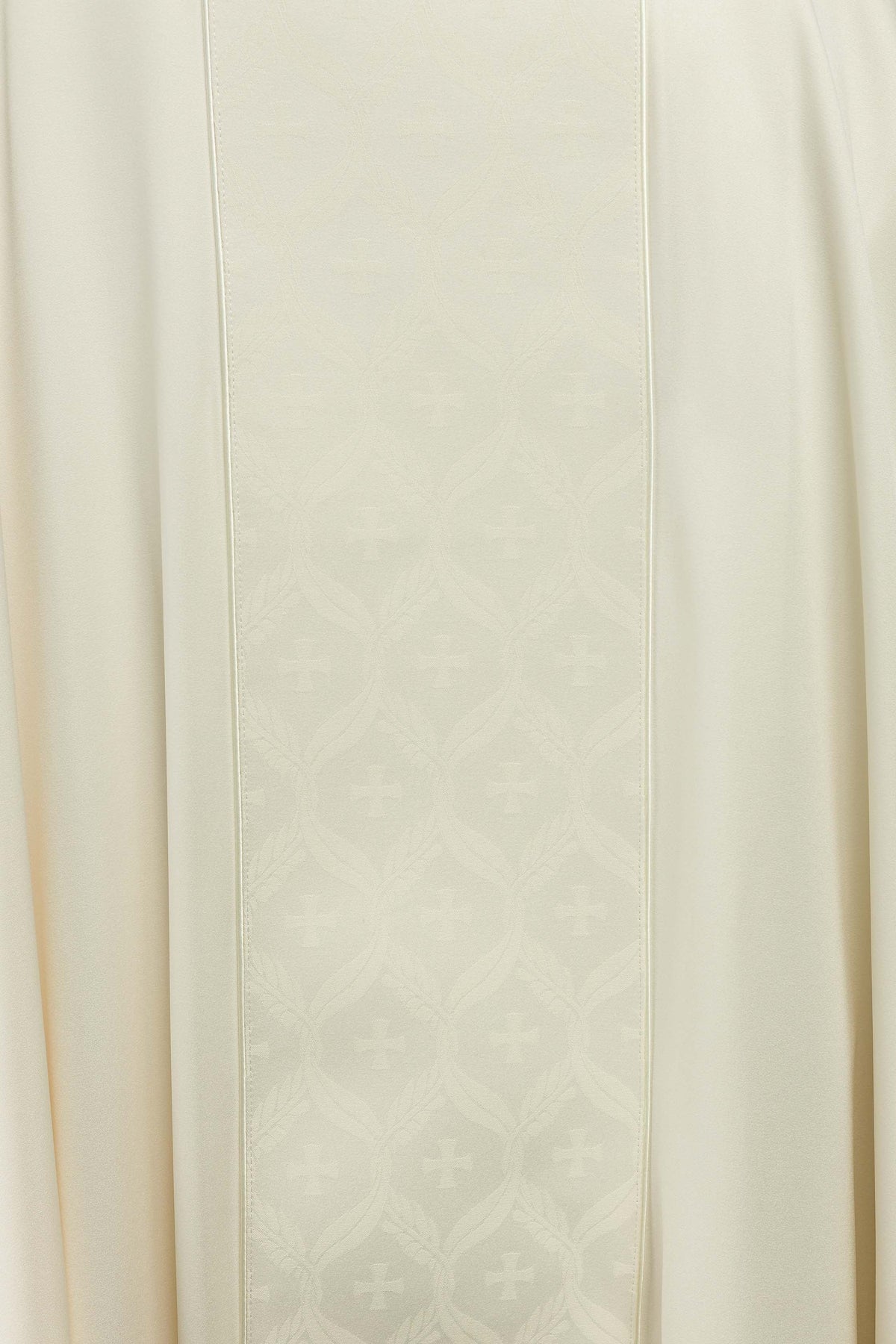Casula creme com faixa jacquard de cruzes em close-up, mostrando as cruzes da faixa central