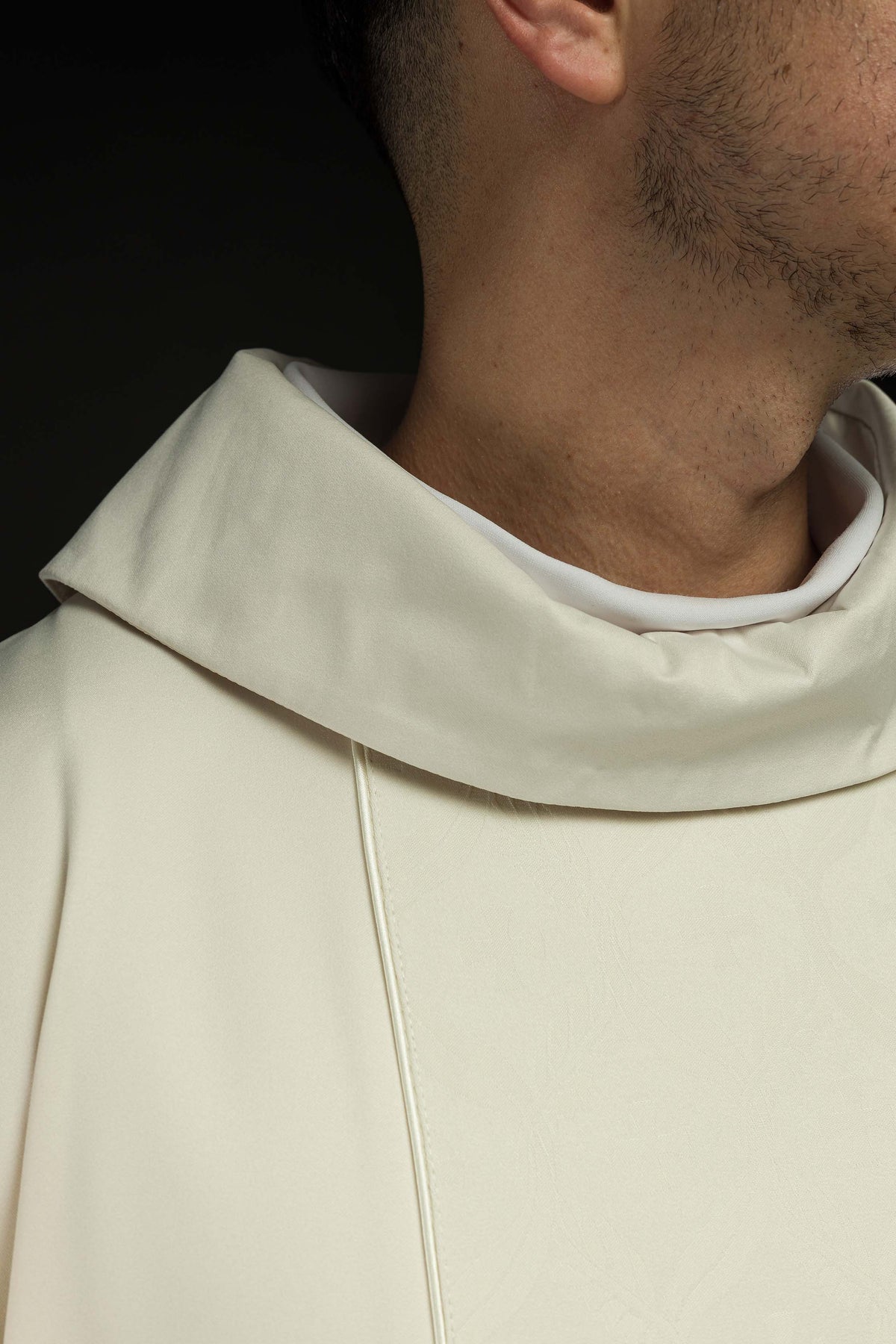Casula creme com faixa jacquard de cruzes em detalhe da gola ampla e costura frontal