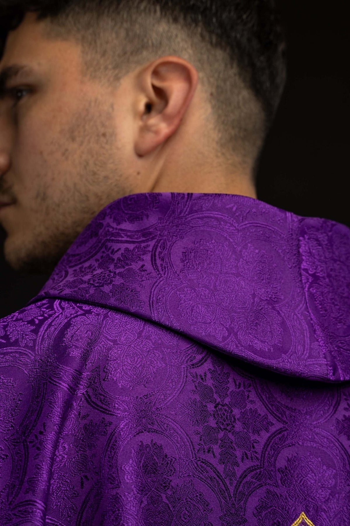 Casula roxa com gola dobrada, detalhe do tecido jacquard