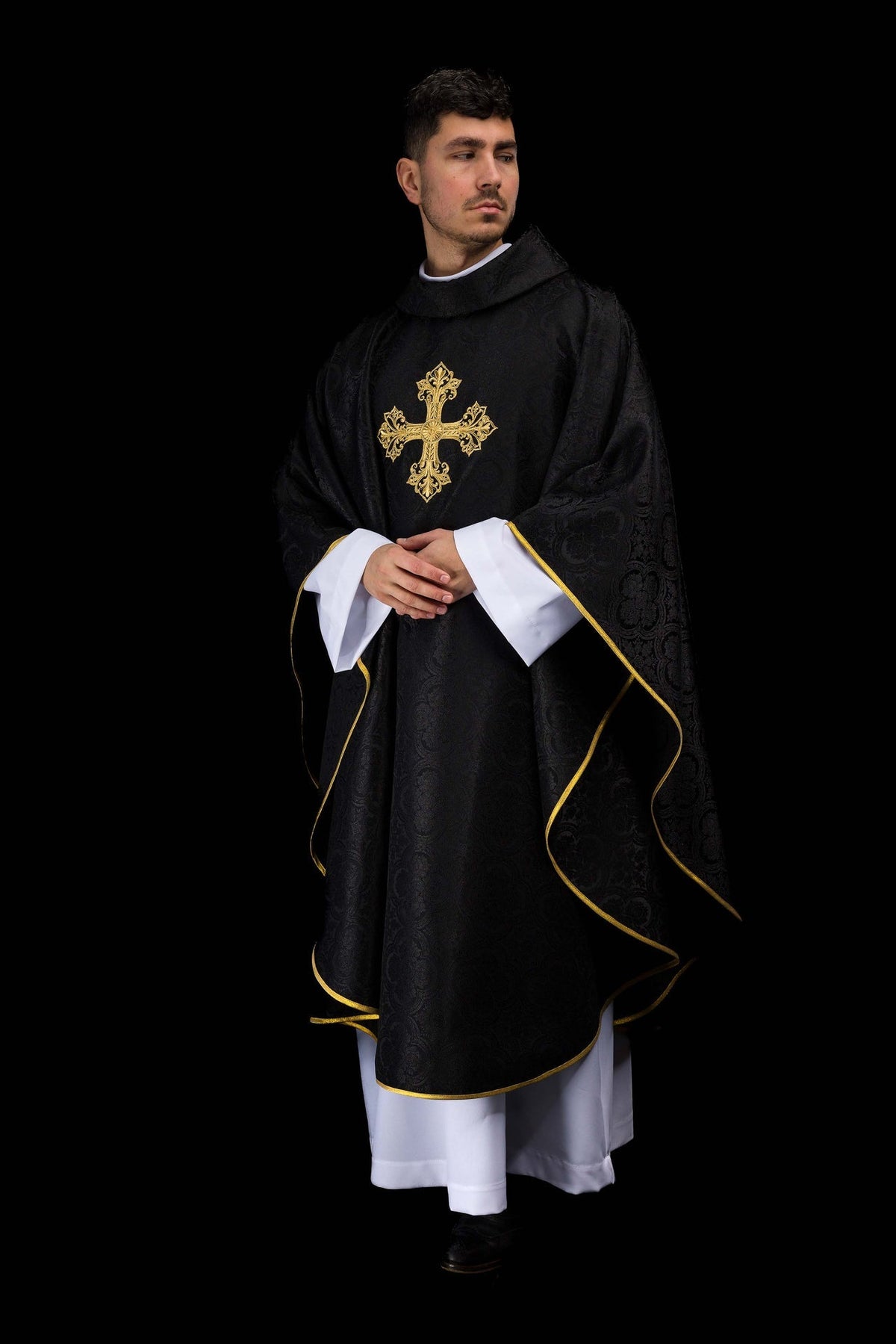 Casula preta jacquard com cruz dourada vista de frente, com acabamento dourado nas bordas
