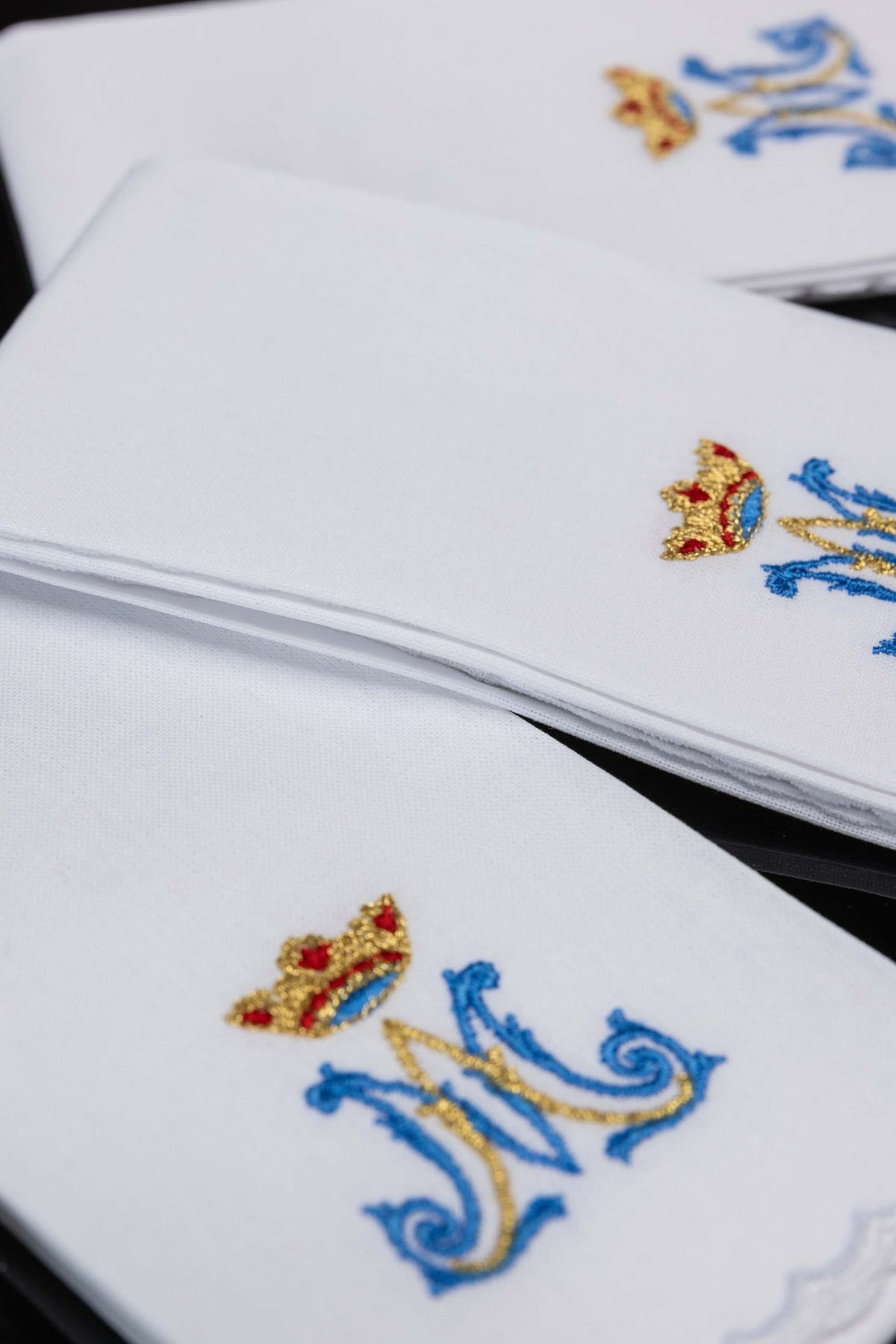 Sanguíneos litúrgicos brancos dobrados, com detalhe de bordado mariano e acabamento nas bordas