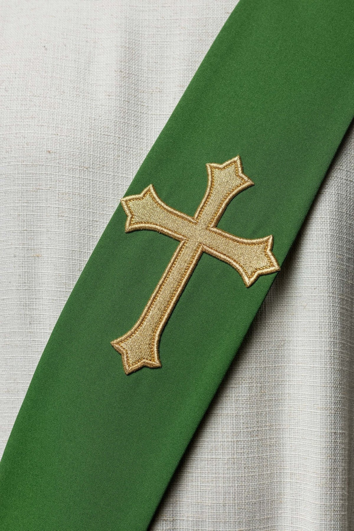 Estola diaconal verde, close-up da cruz dourada bordada