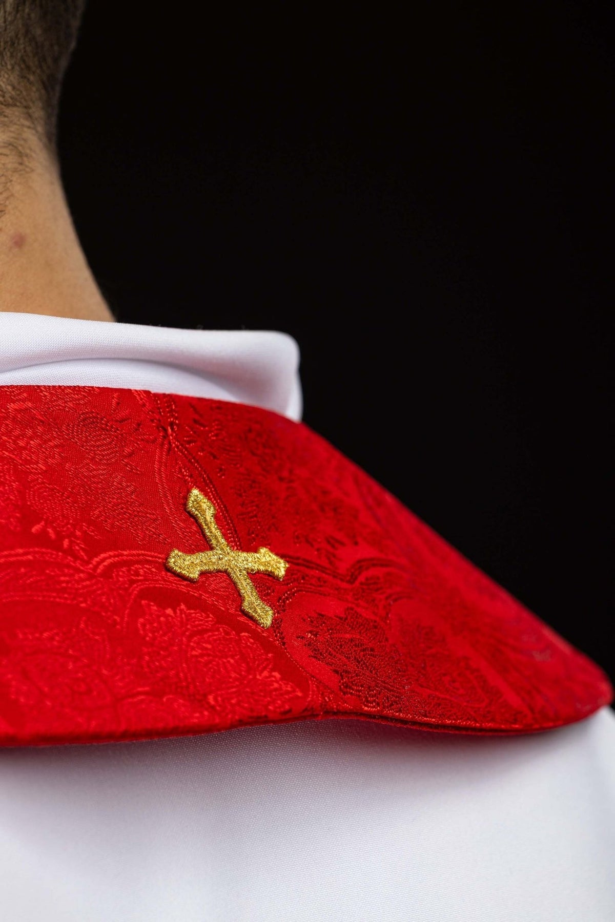 Estola sacerdotal vermelha em tecido jacquard, detalhe lateral da cruz dourada bordada