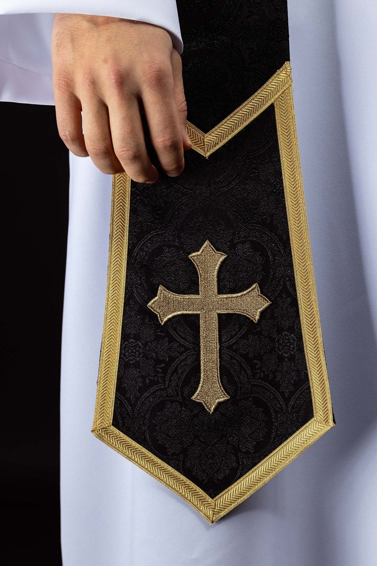 Estola preta com Cruz dourada bordada e acabamento dourado em close-up