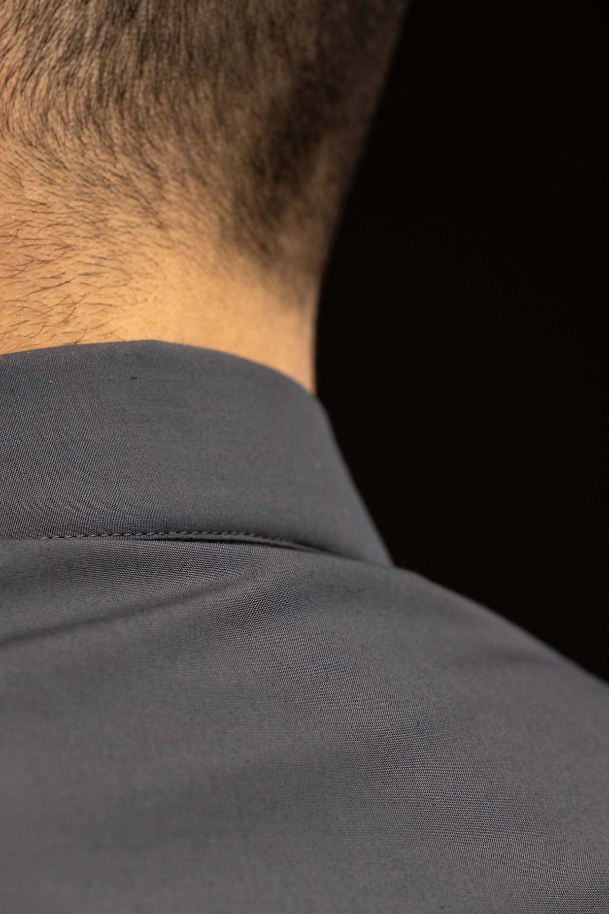 Camisa clerical cinza-escura com close-up da costura do ombro