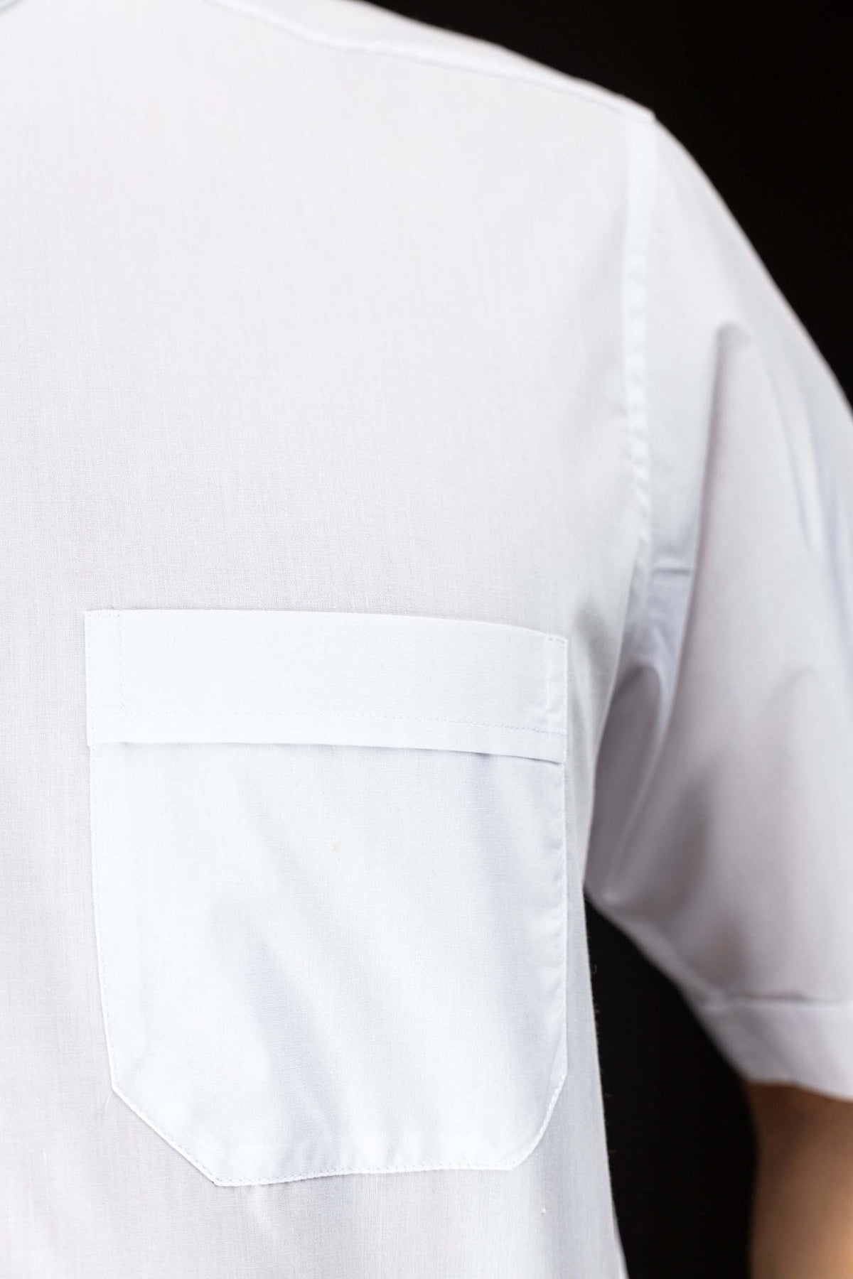 Camisa clerical branca em close-up do bolso frontal com aba