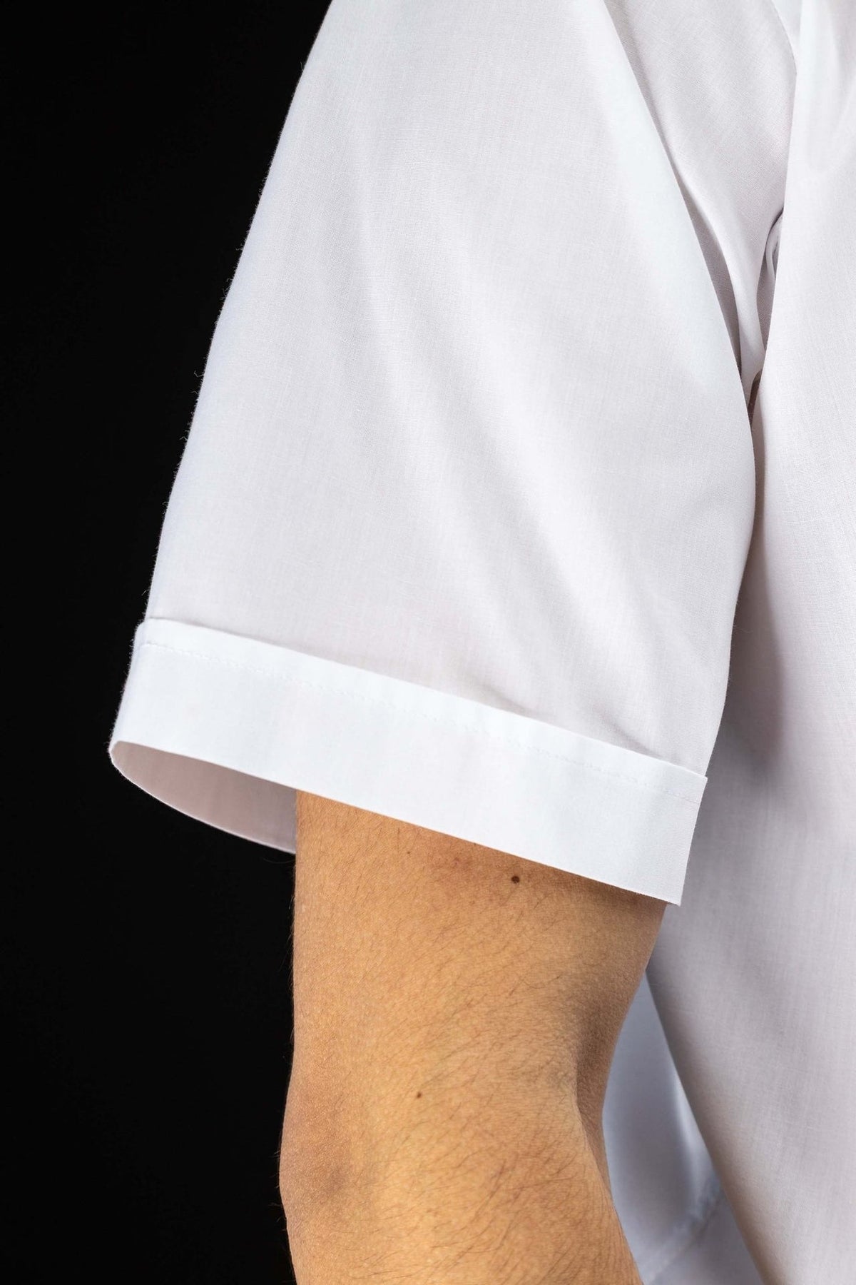 Camisa clerical branca em close-up da manga curta com barra dobrada
