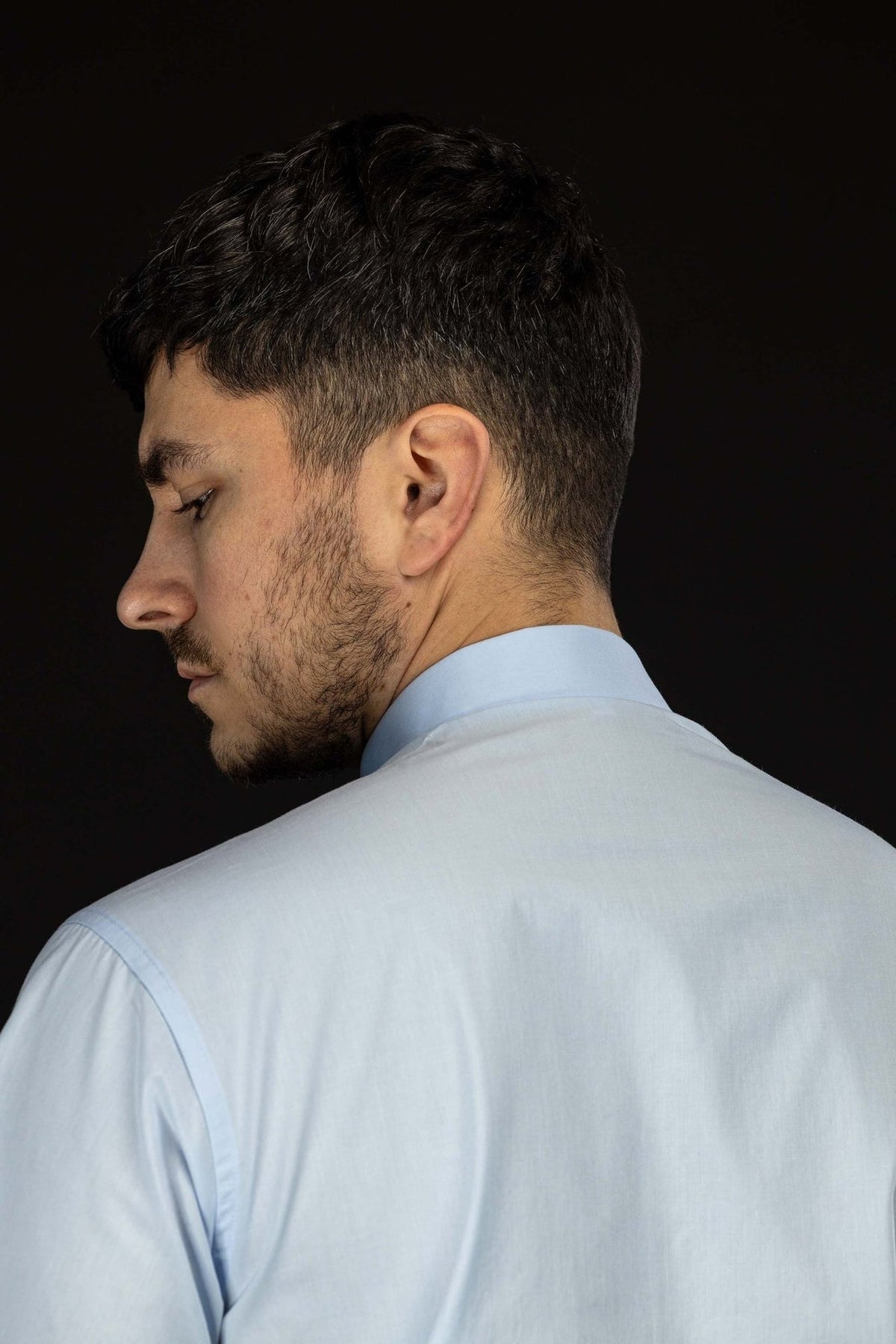 Camisa clerical azul-clara vista de lado e por trás, mostrando o colarinho clerical