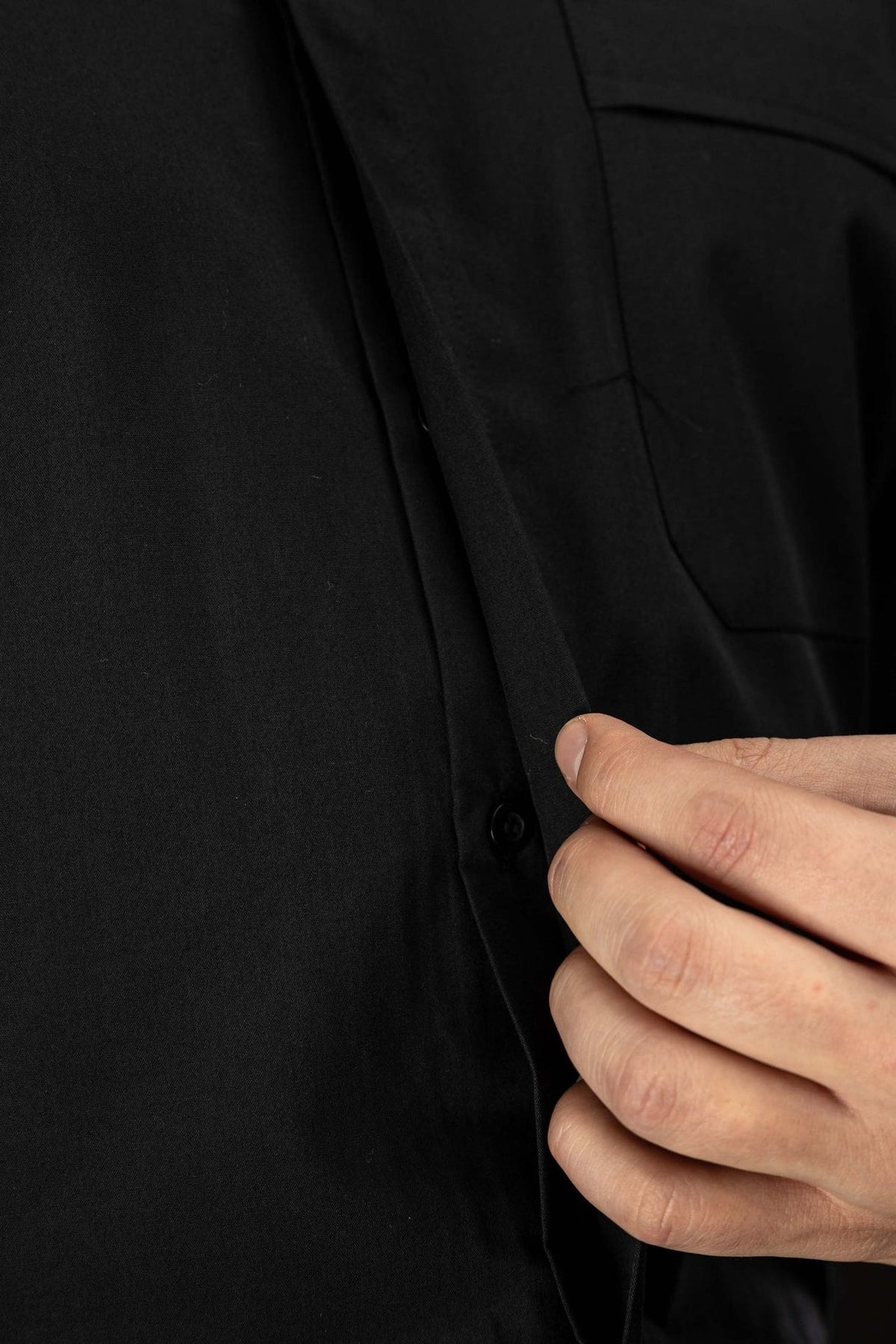 Camisa clerical preta em close-up, mostrando punho de manga longa