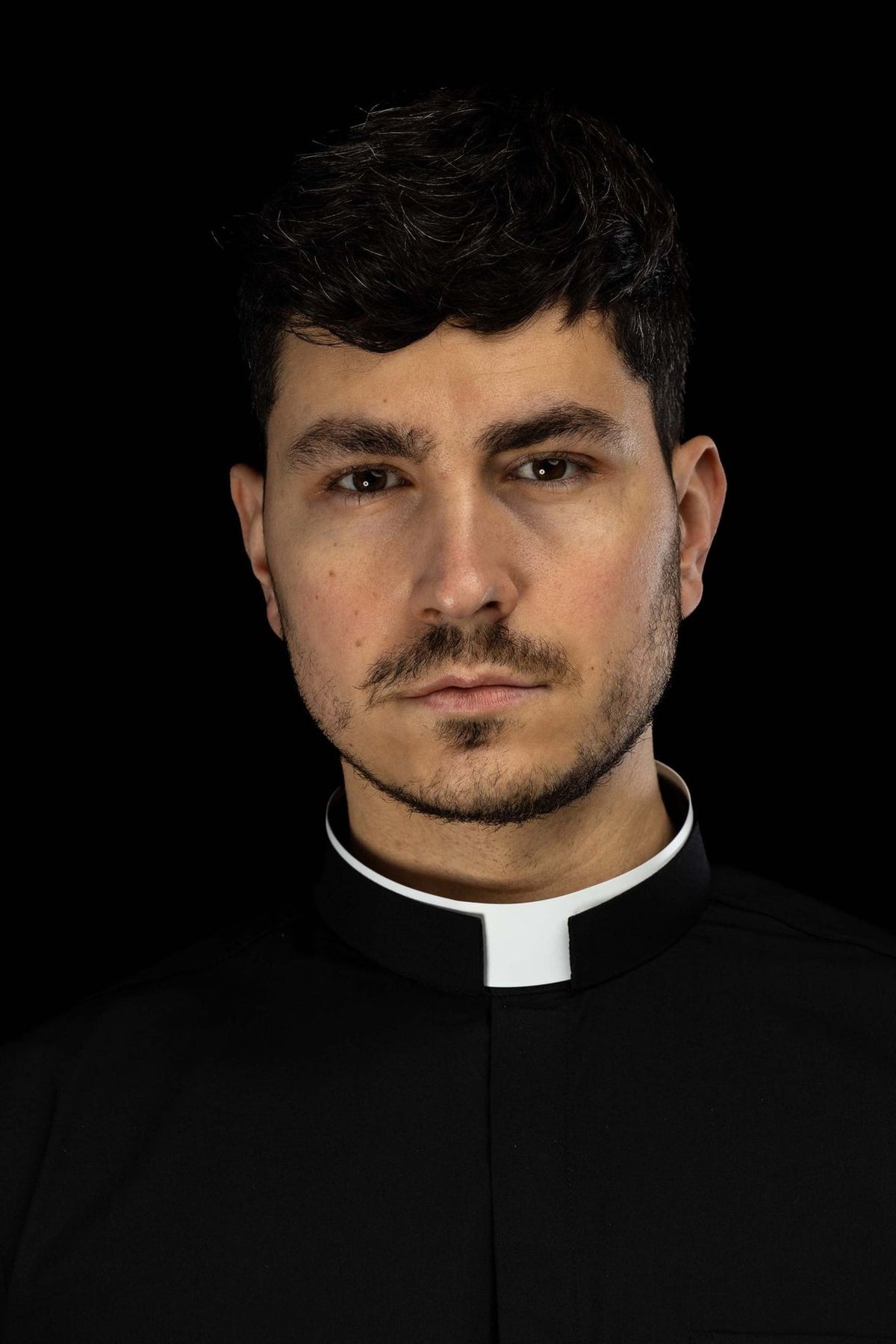 Camisa clerical preta em close-up, mostrando fechamento frontal com botões