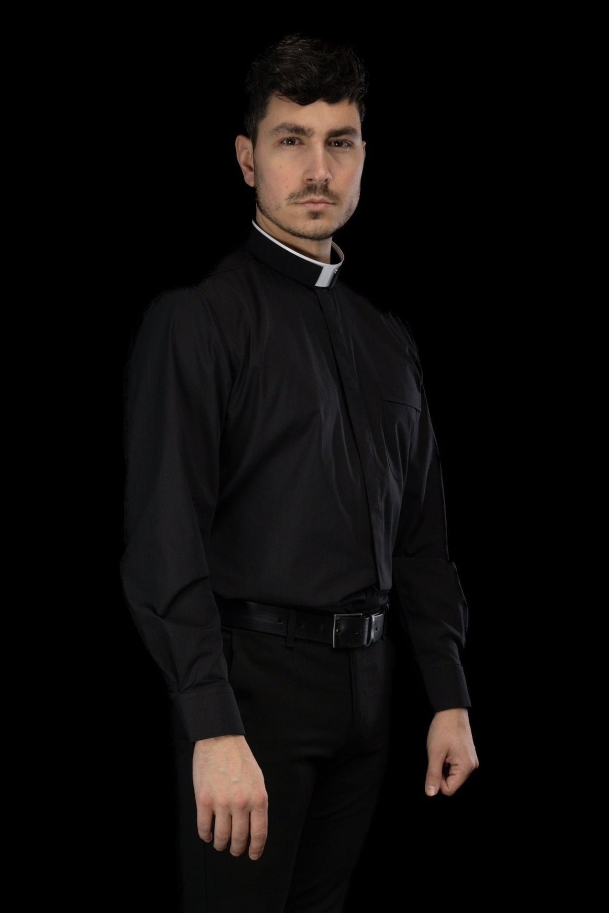 Camisa clerical preta em vista lateral, com colarinho romano e mangas longas