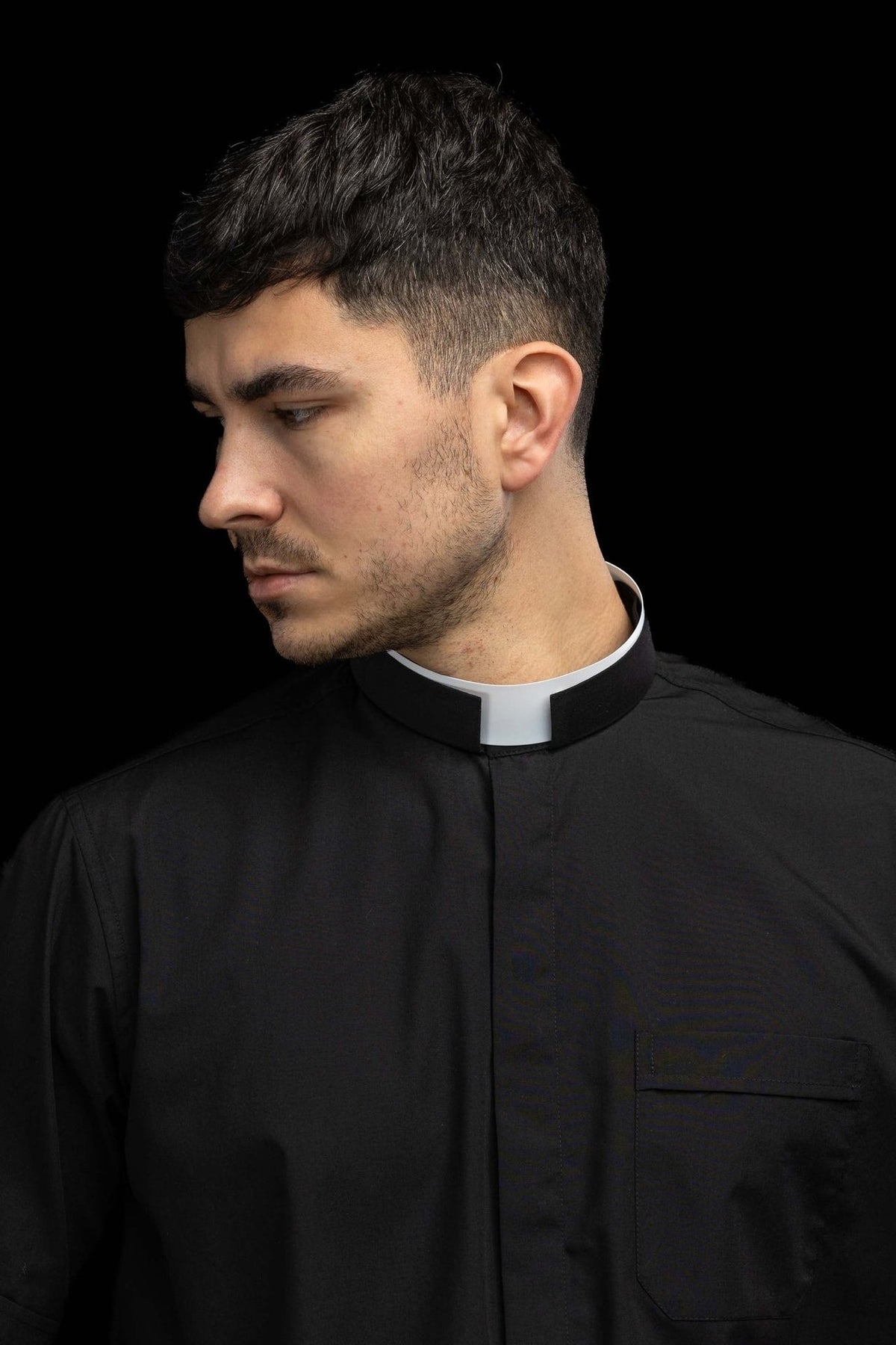 Camisa clerical preta com colarinho romano, vista frontal em close-up