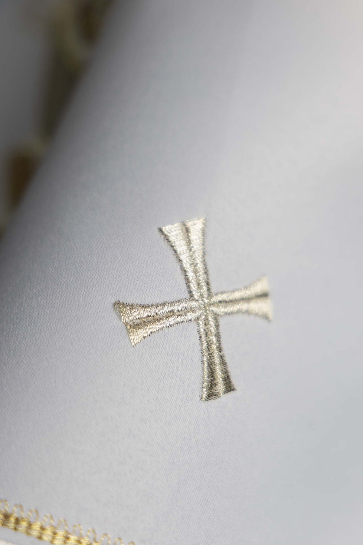 Véu de âmbula com close de cruz bordada em branco