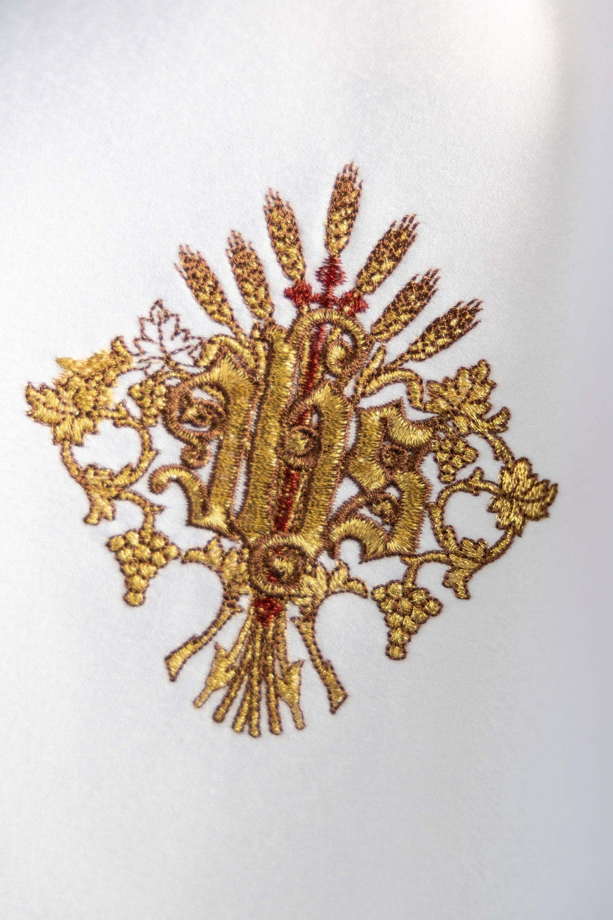 Véu de âmbula com close-up do bordado dourado do monograma IHS