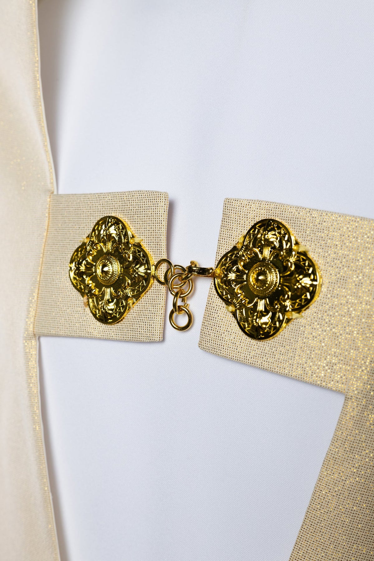 Véu umeral com fecho dourado e detalhes ornamentais nas pontas