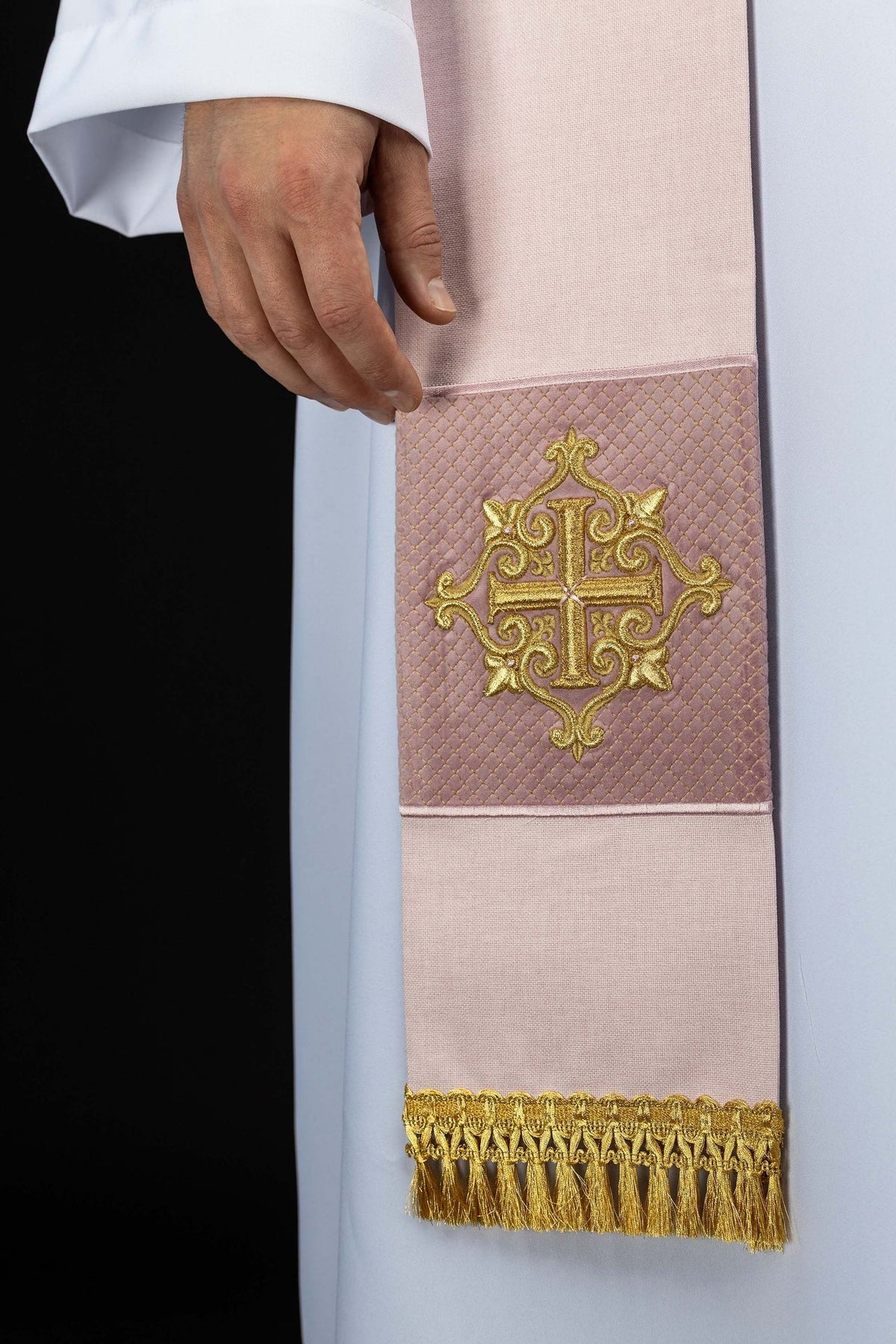 Estola rosa com close-up da cruz dourada bordada em faixa matelassada e franjas