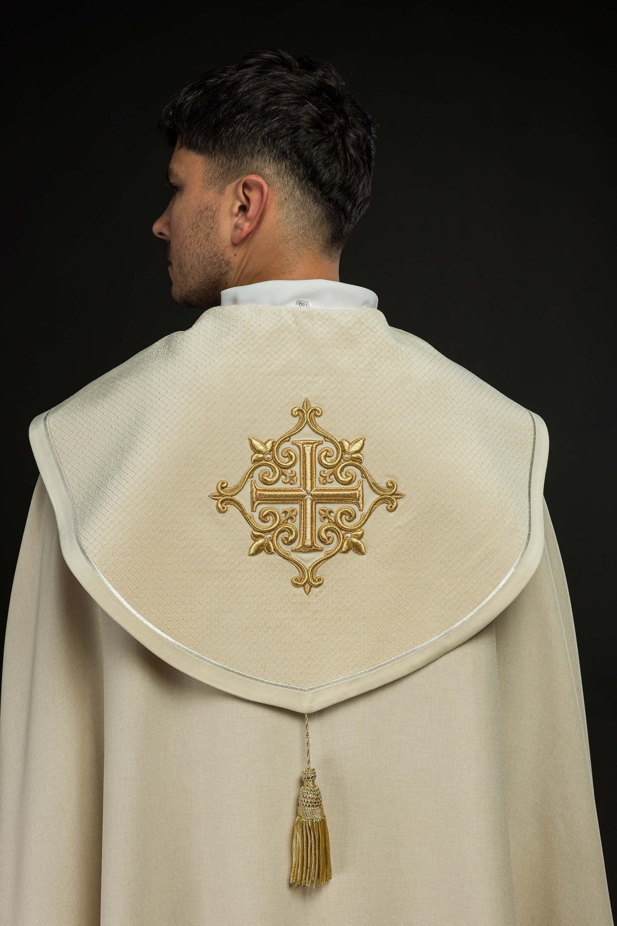 Capa de asperges litúrgica com faixa de veludo creme e bordado de cruzes, vista posterior