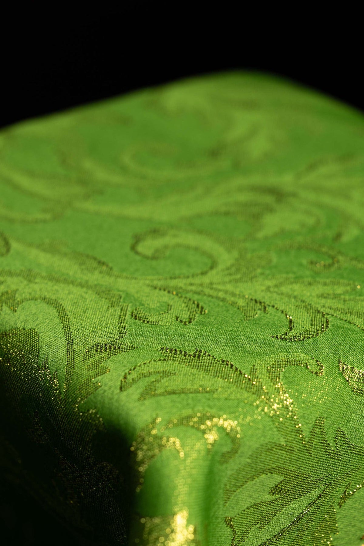 Véu de cálice verde em close-up, mostrando o tecido com padrão dourado