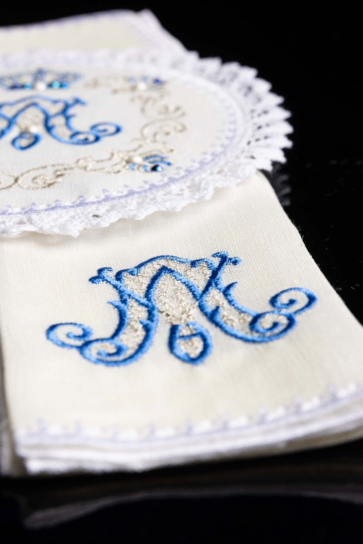 Alfaias de linho com detalhe do monograma mariano azul e contorno dourado