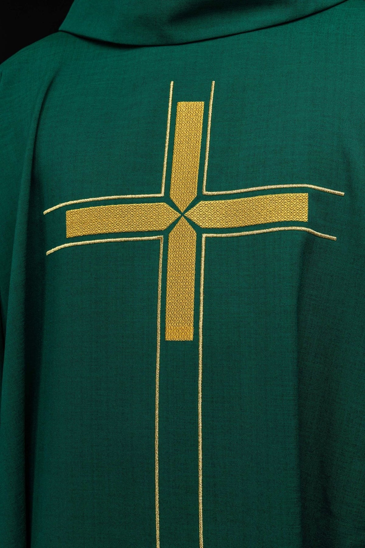 Casula verde em close-up frontal, destacando a cruz dourada com bordado texturizado