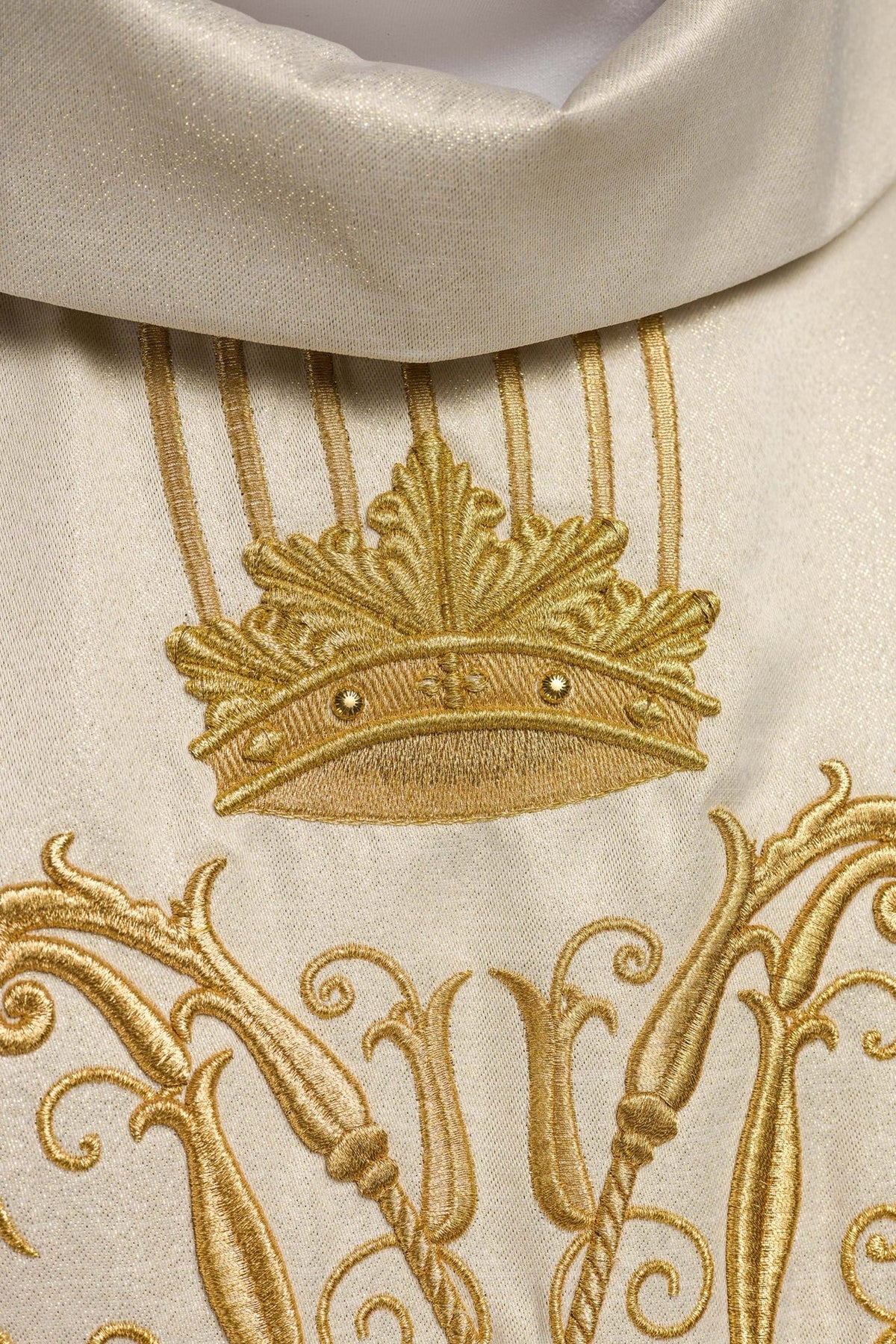 Casula litúrgica em detalhe, com tecido marfim ecru brilhante e bordado dourado