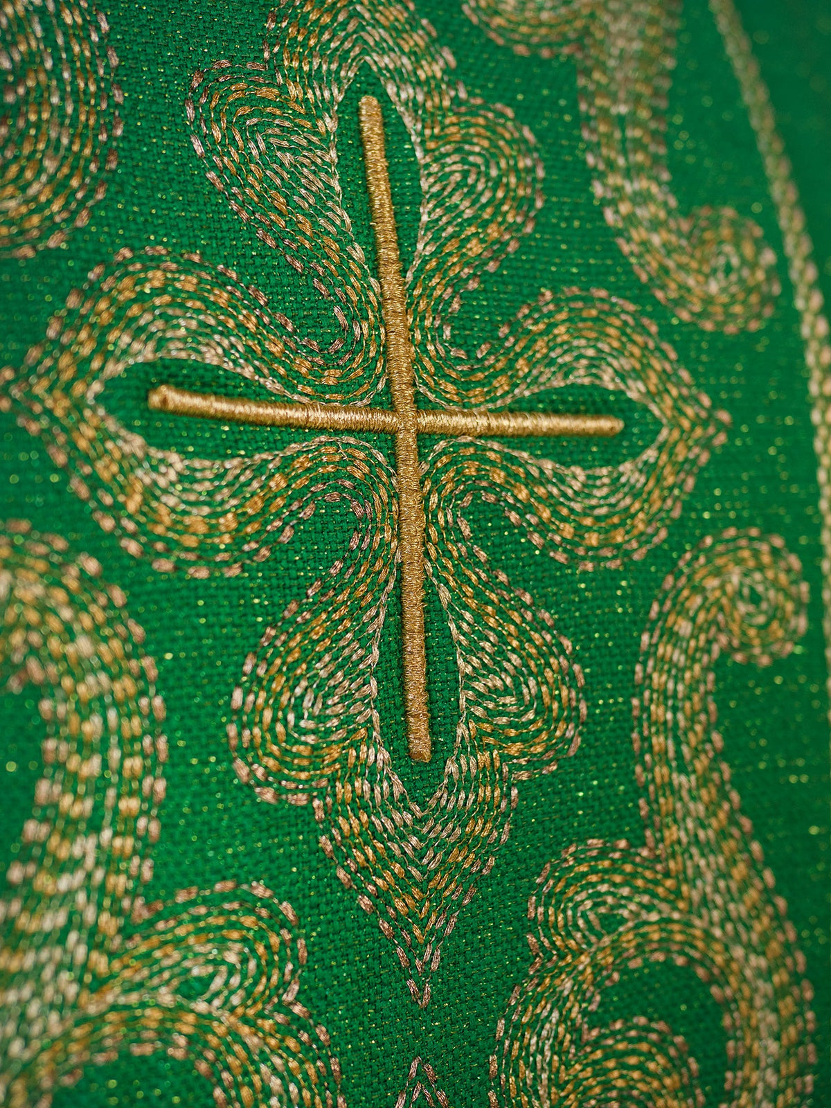 Casula verde com close-up do bordado dourado de uma cruz