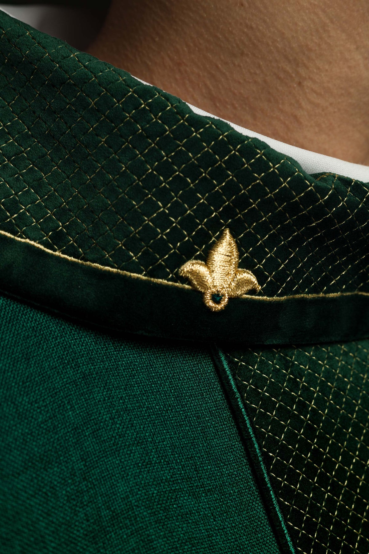 Casula verde, close-up da gola com bordado dourado em padrão losango