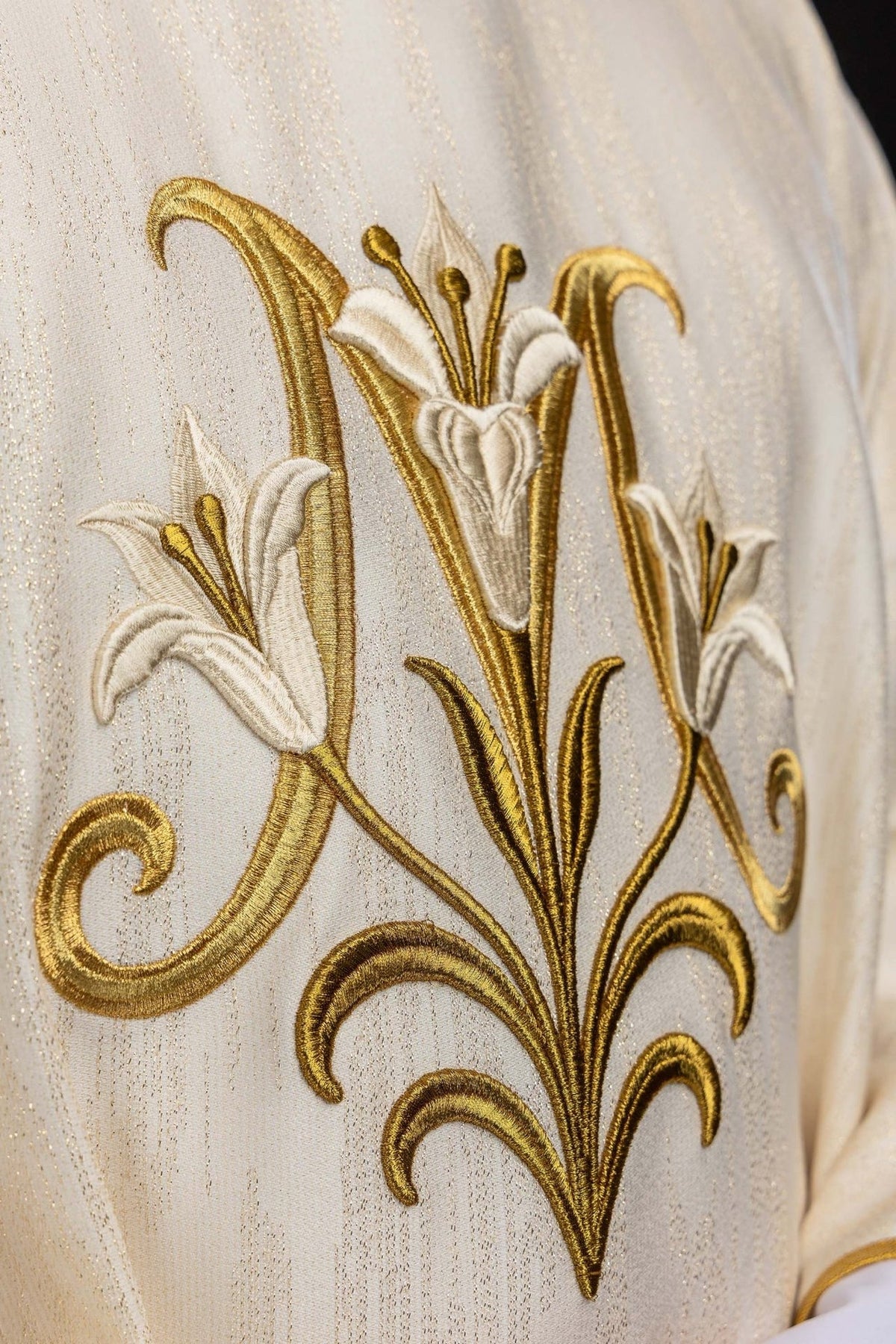 Casula mariana marfim ecru em close-up, mostrando o bordado de lírios dourado e branco