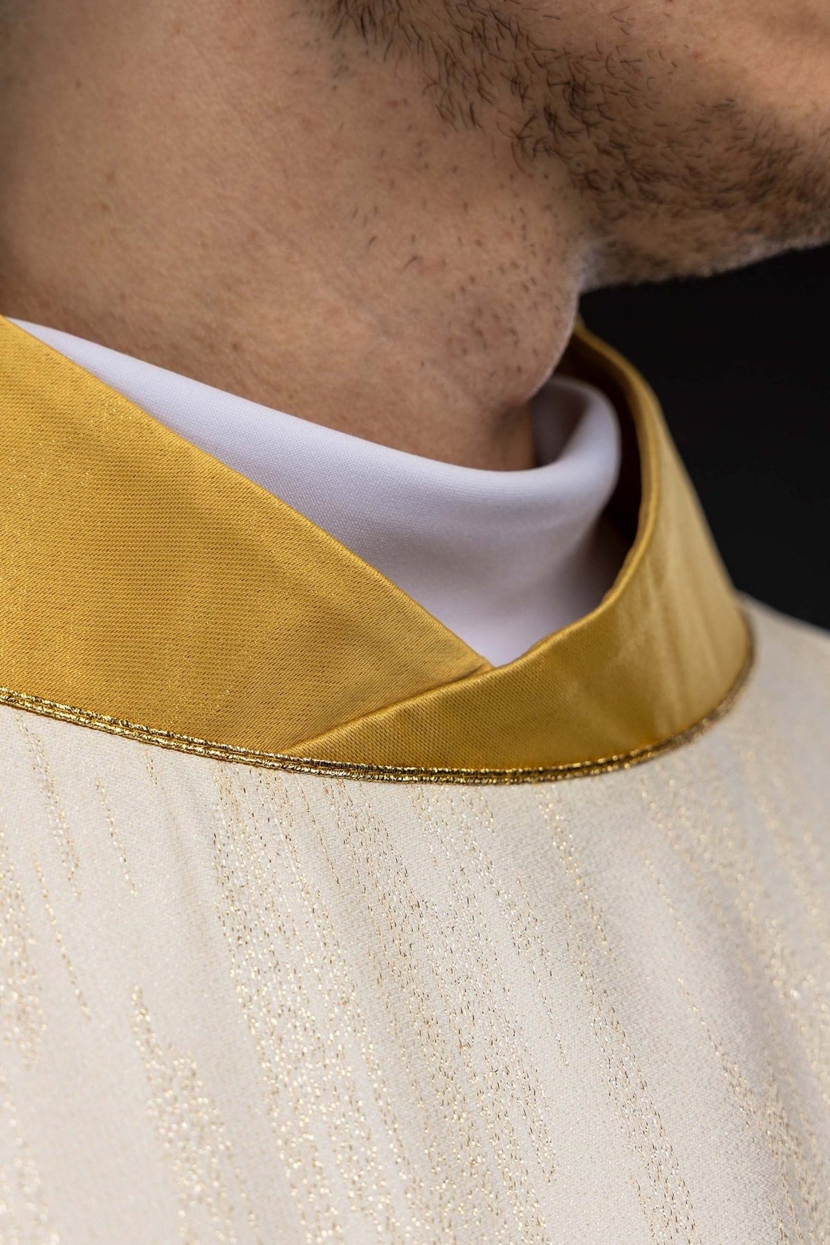 Casula mariana marfim ecru vestida, destacando o bordado frontal e o viés dourado das mangas